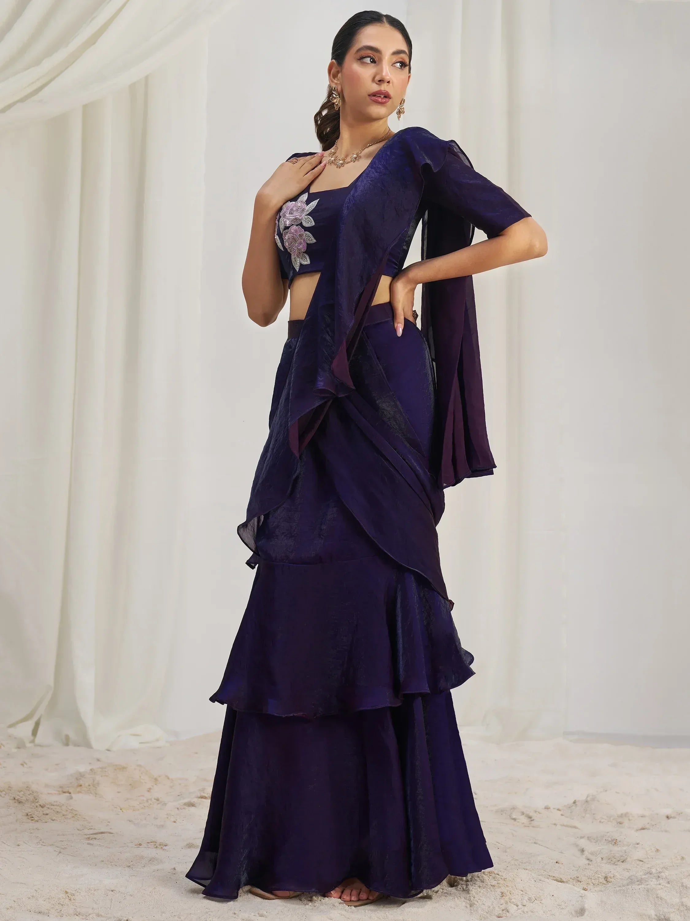 Elegant purple ethnic gown with floral embroidery and layered skirt, perfect for Indian celebrations.