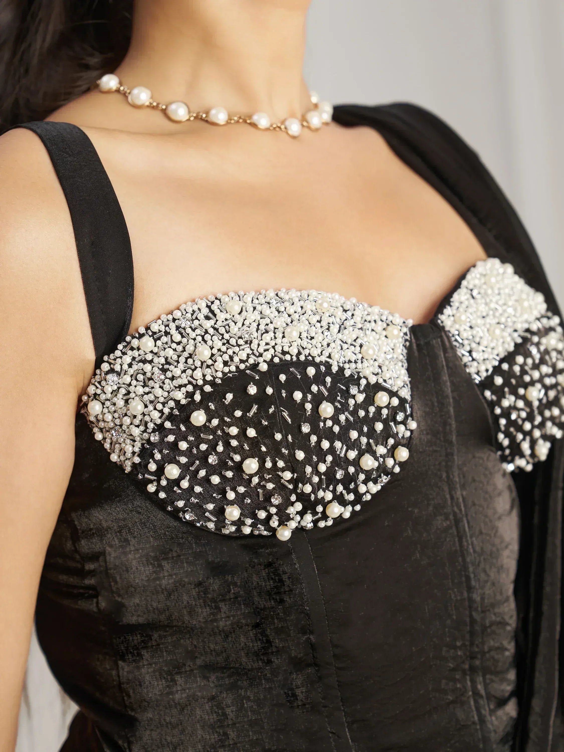 Black velvet ethnic gown with pearl and bead embellishments, paired with pearl necklace