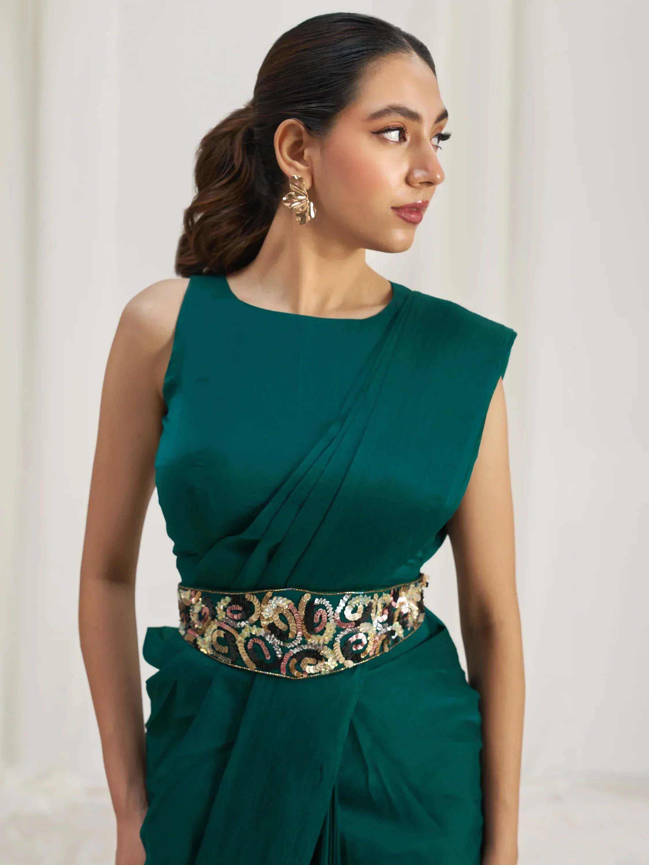 Emerald green ethnic gown with sequined waistband, perfect for Indian festive occasions