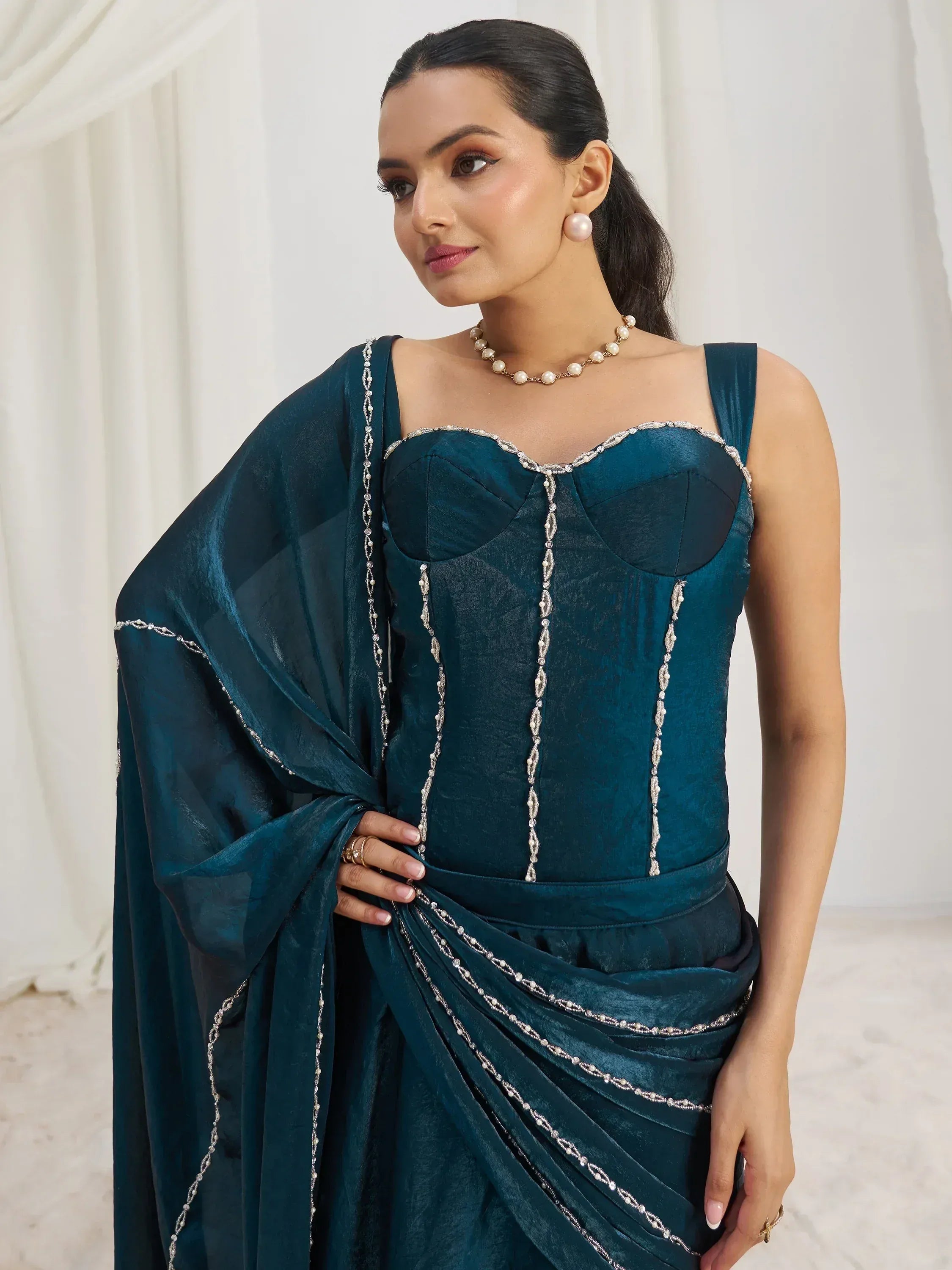 Elegant teal designer saree with pearl embellishments and corset-style blouse