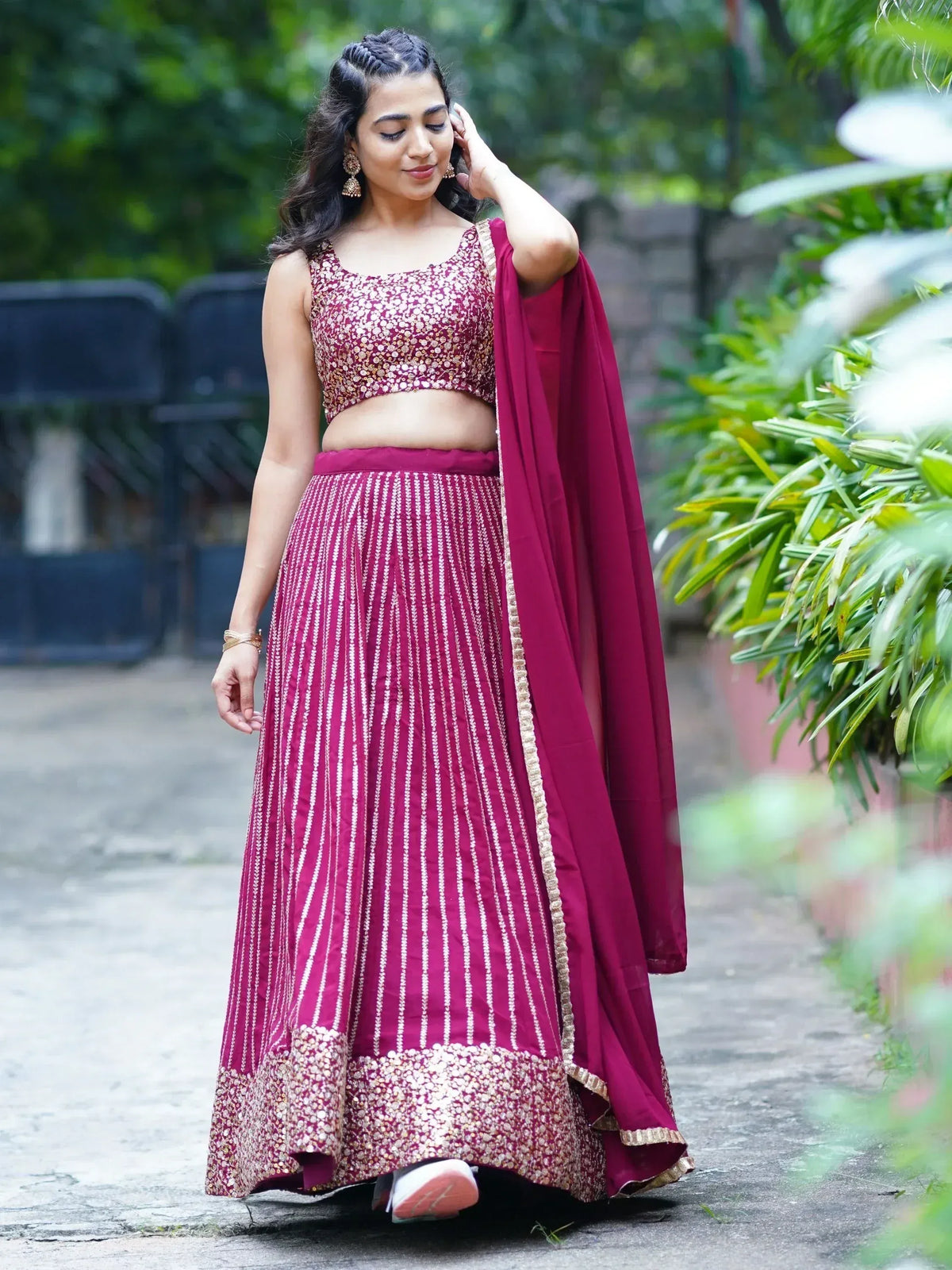 Woman in maroon designer lehenga choli with gold embroidery, perfect for Indian ethnic wear occasions