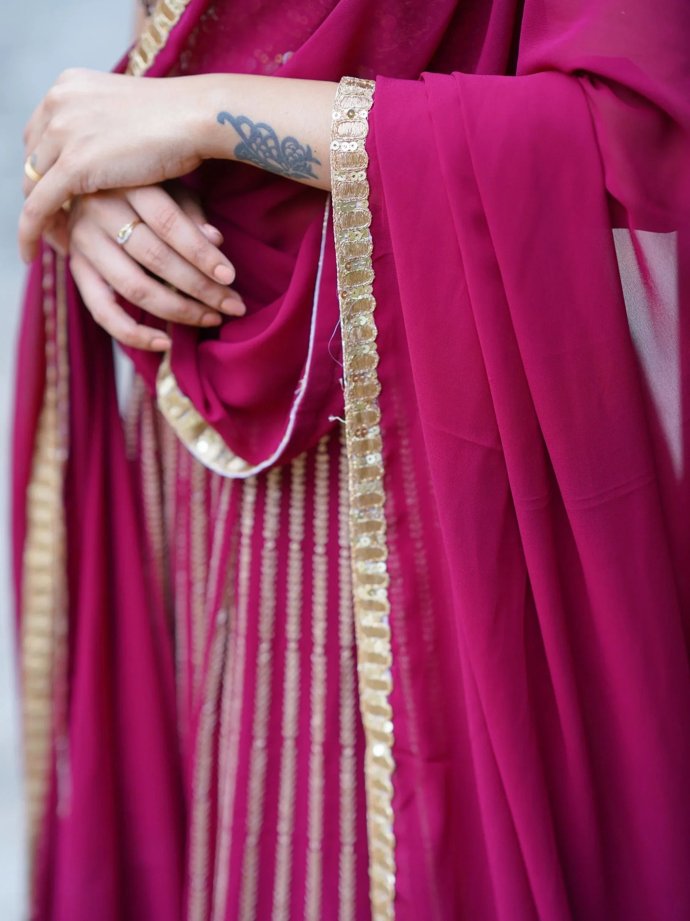 Magenta ethnic gown with gold sequin border and detailed embroidery, perfect for Indian occasions