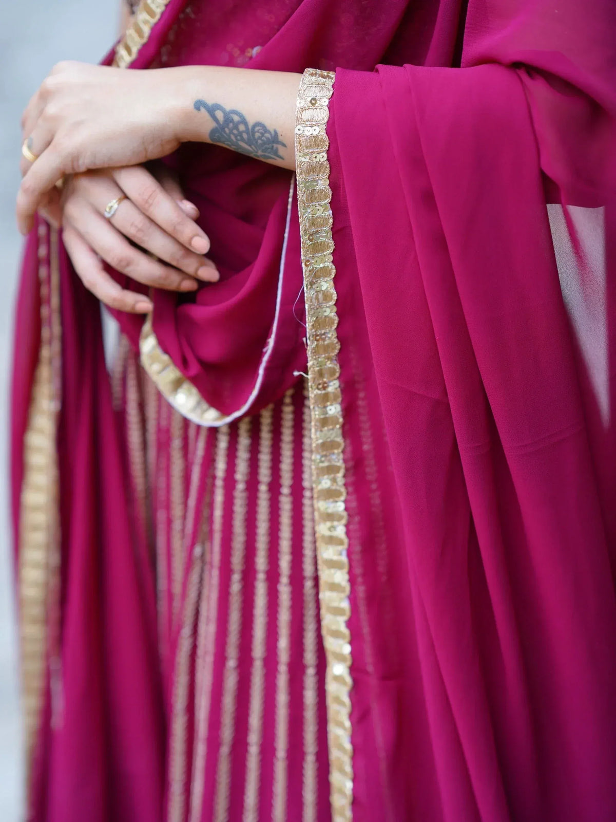 Magenta ethnic gown with gold sequin border and detailed embroidery, perfect for Indian occasions