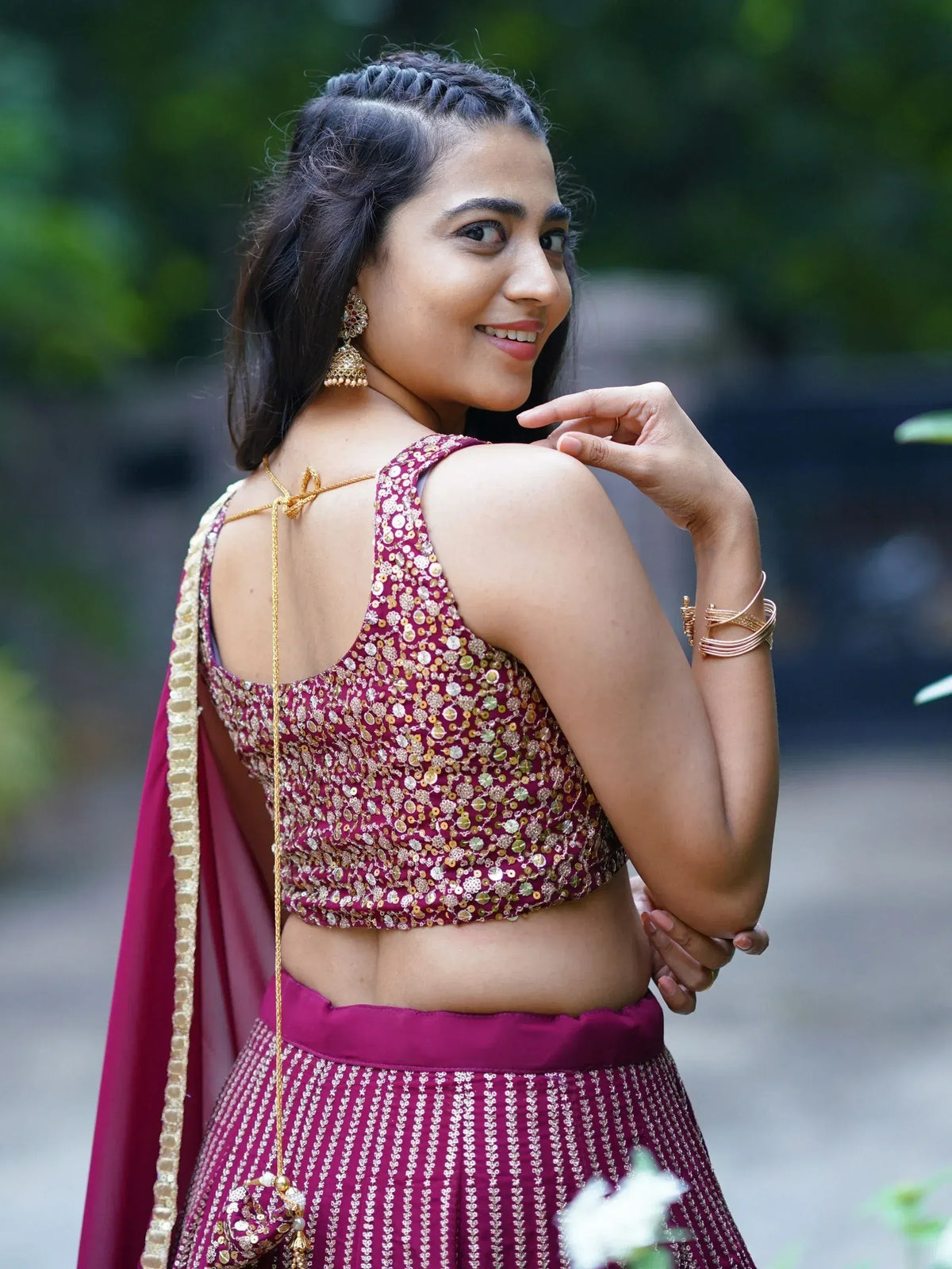 Woman in maroon sequined lehenga choli with gold embroidery, traditional Indian ethnic wear