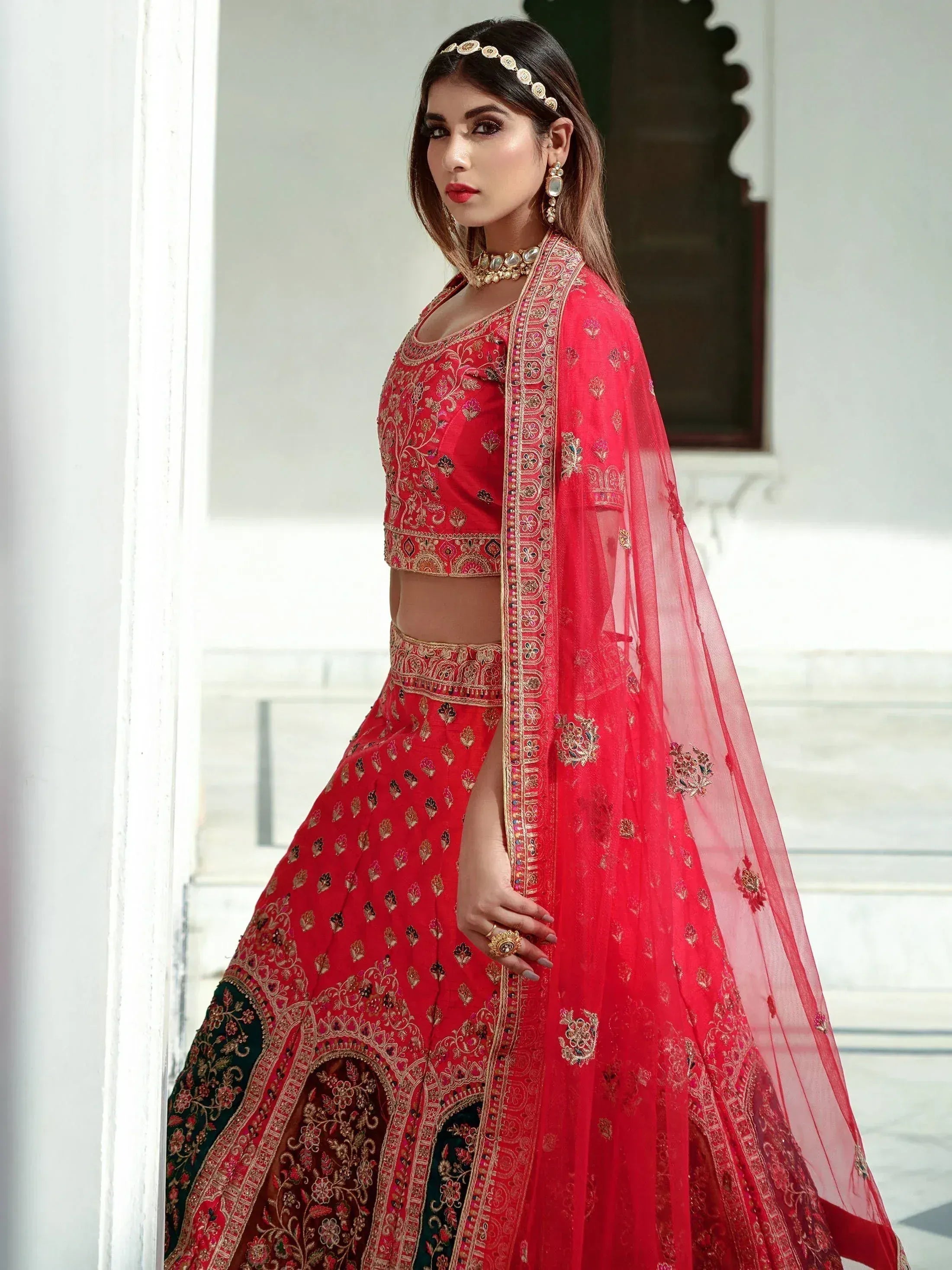 Red embroidered lehenga choli with gold detailing, perfect for Indian weddings and festive occasions.