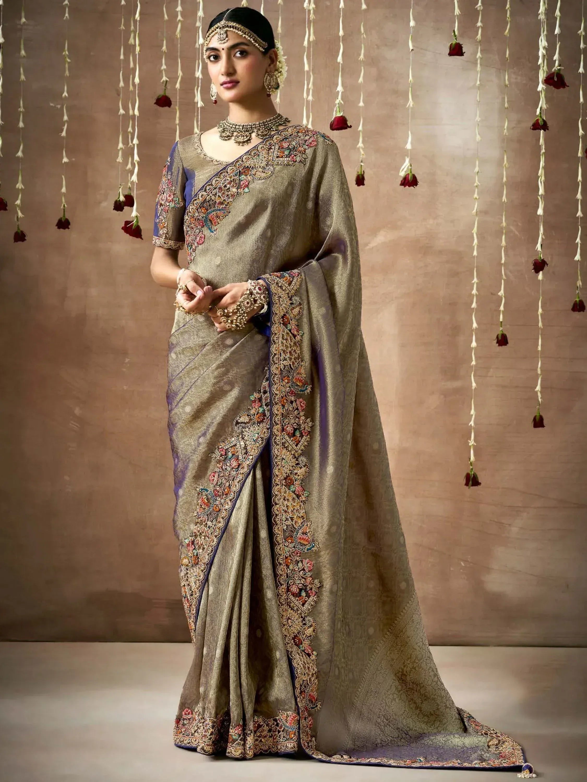 Elegant beige saree with intricate floral embroidery and blue border, perfect for Indian ethnic occasions.