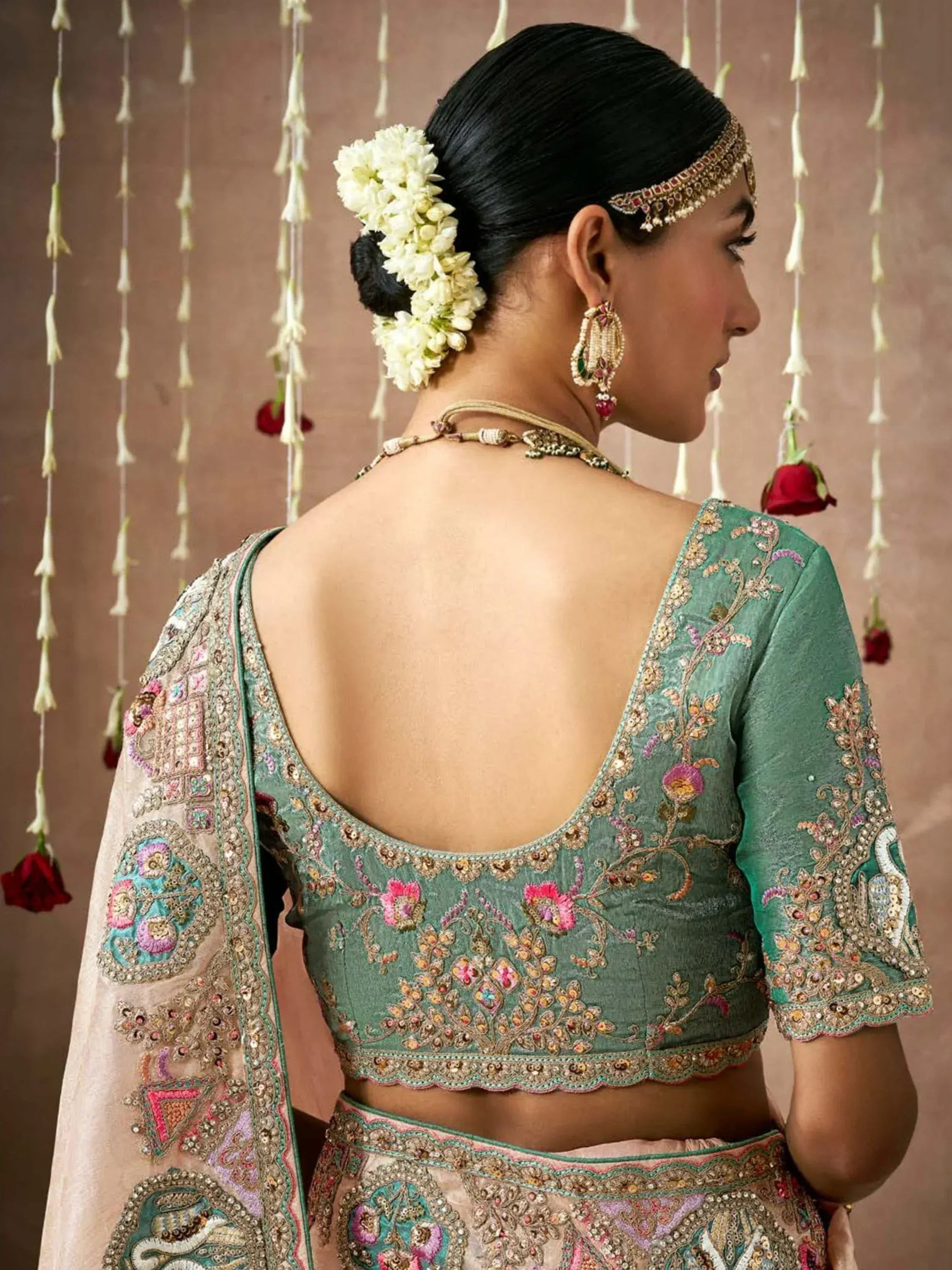 Elegant green embroidered lehenga choli with floral back design, perfect for Indian weddings and festive occasions.