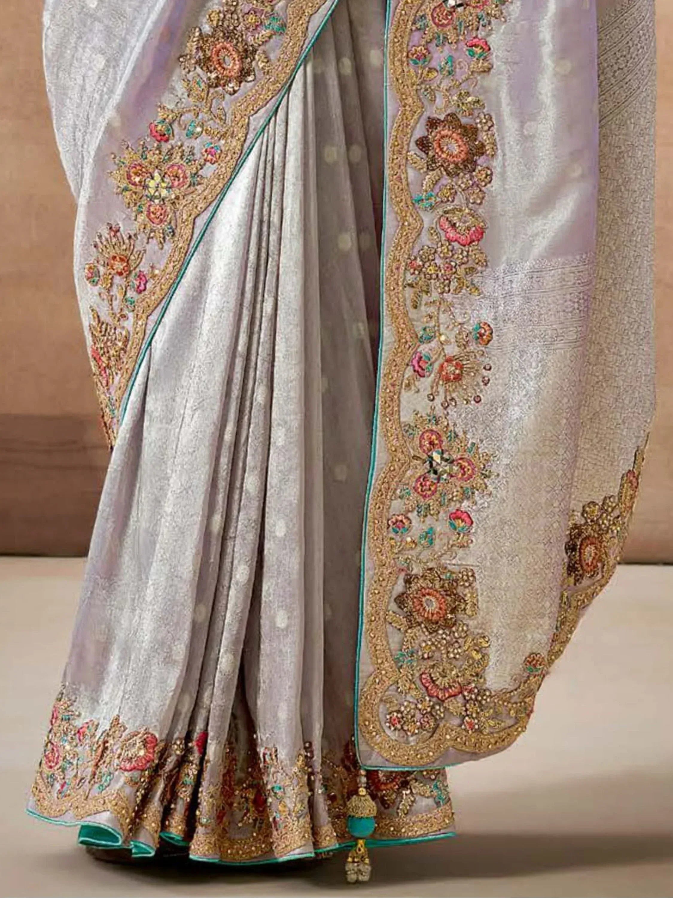 Elegant silver saree with intricate floral embroidery and gold zari work, perfect for Indian ethnic occasions.