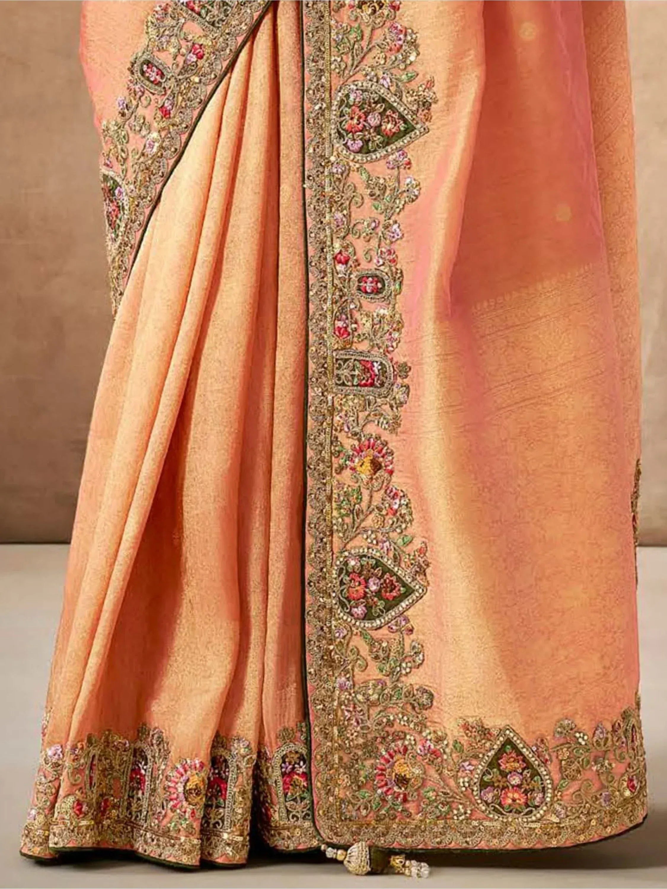 Peach designer saree with intricate floral embroidery and golden border, perfect for Indian ethnic wear occasions.