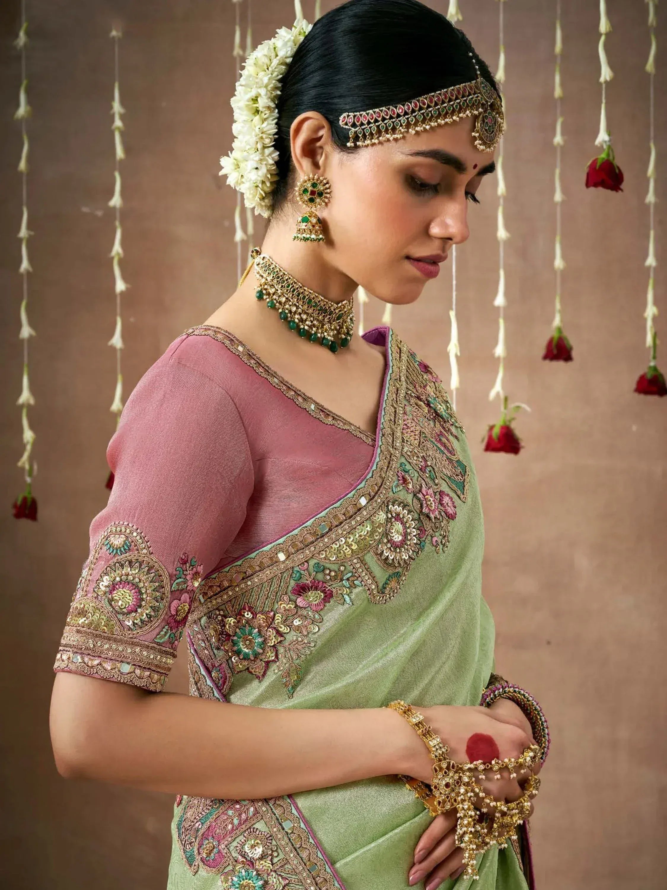 Elegant Indian saree with floral embroidery, paired with traditional jewelry and gajra hair accessory