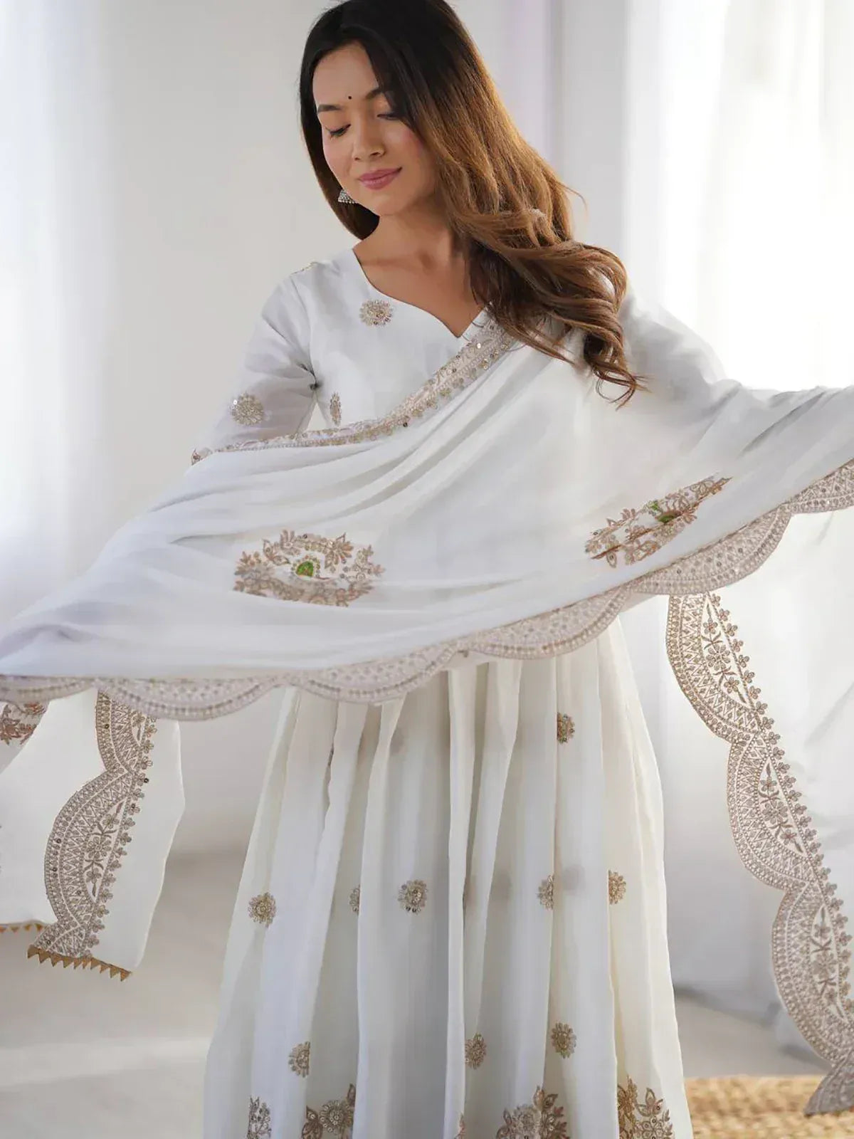 White embroidered salwar kameez with gold detailing, perfect for ethnic occasions and festive wear.