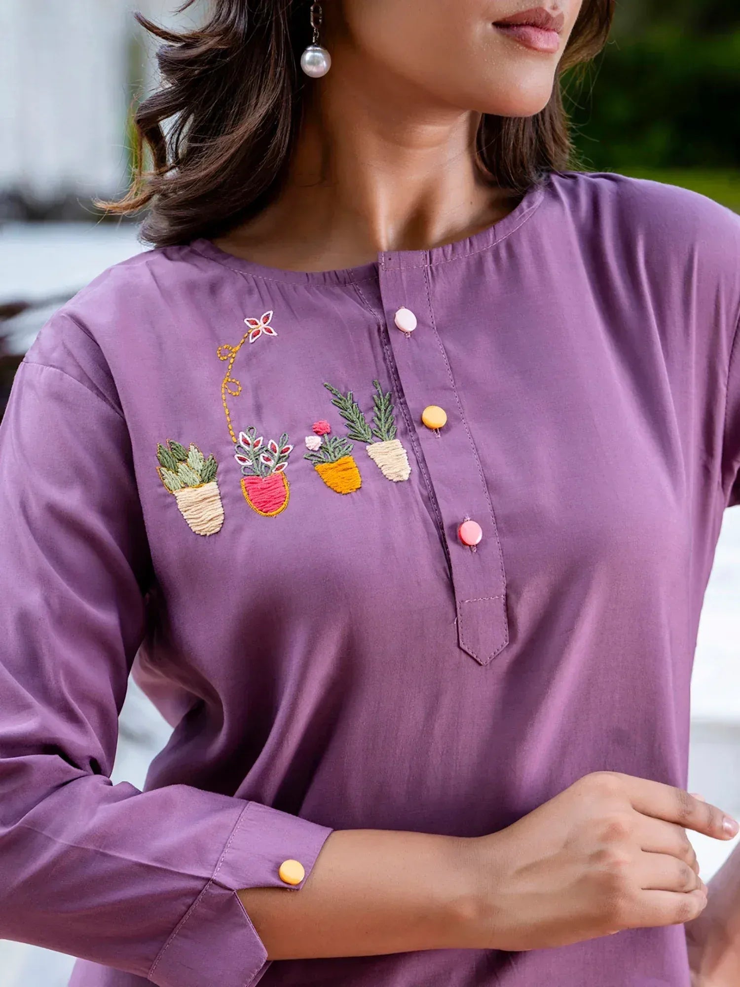 Purple ethnic kurti with floral pot embroidery and colorful buttons, perfect for casual Indian wear