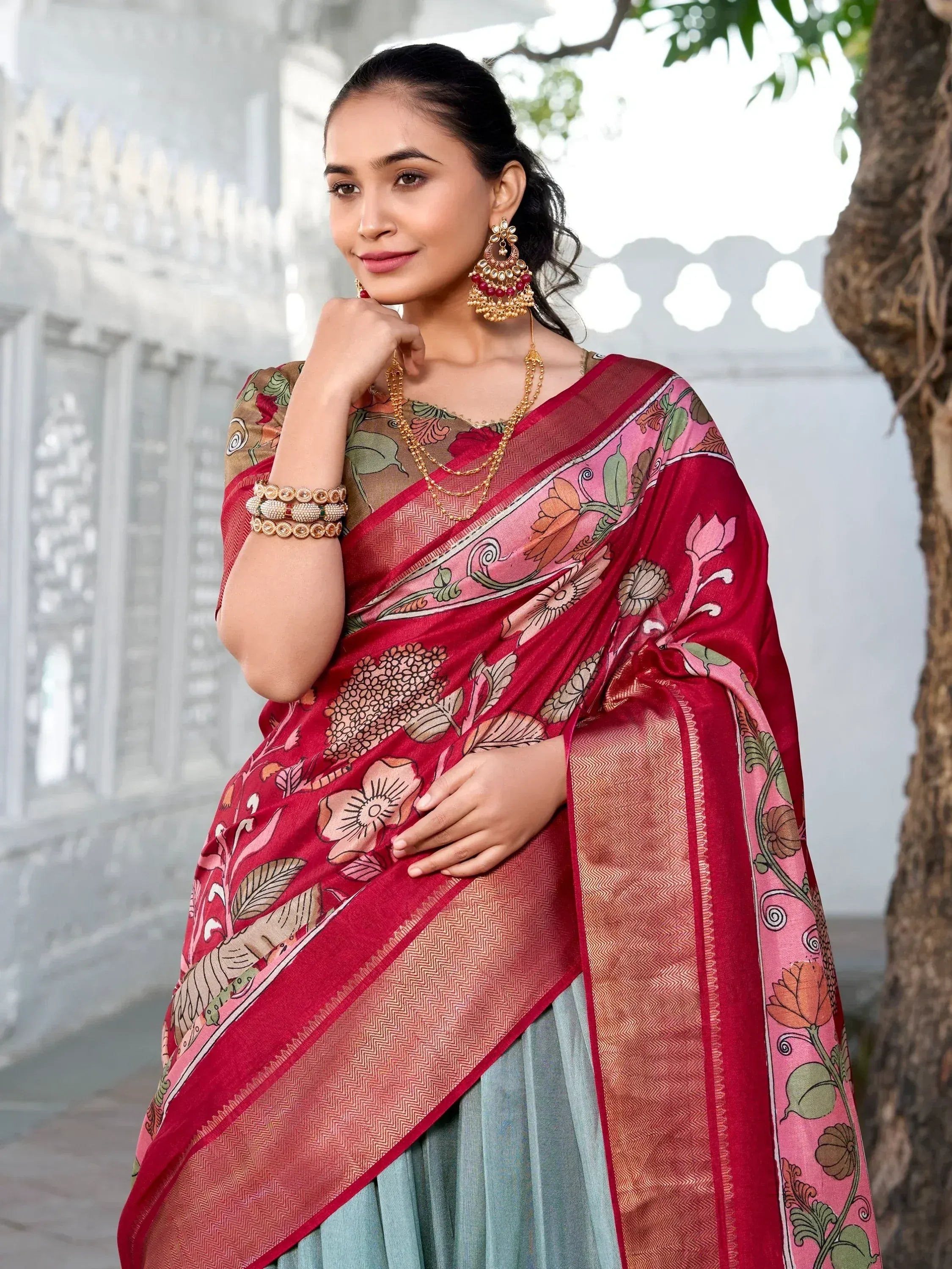 Woman in red floral print saree with gold border, traditional Indian ethnic wear, styled with jhumka earrings