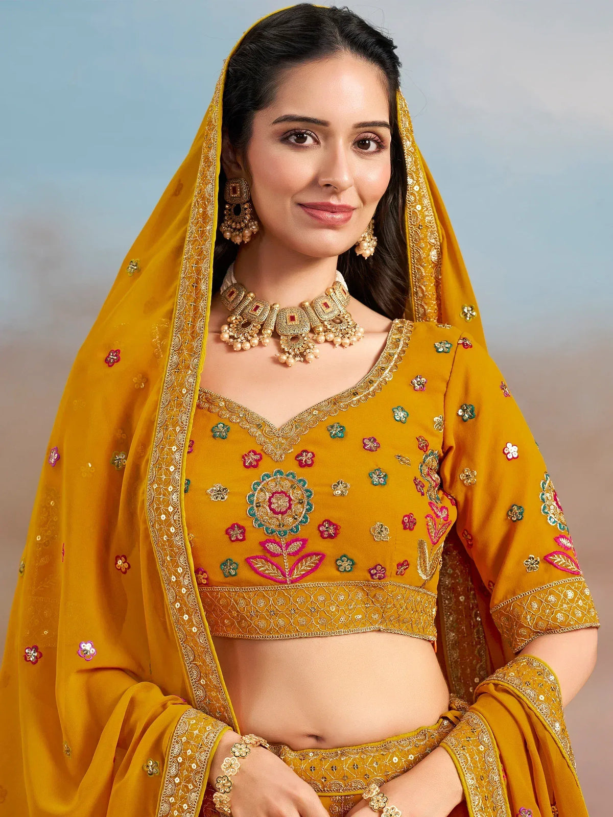 Mustard yellow embroidered lehenga choli with floral motifs and matching dupatta, perfect for Indian ethnic occasions.