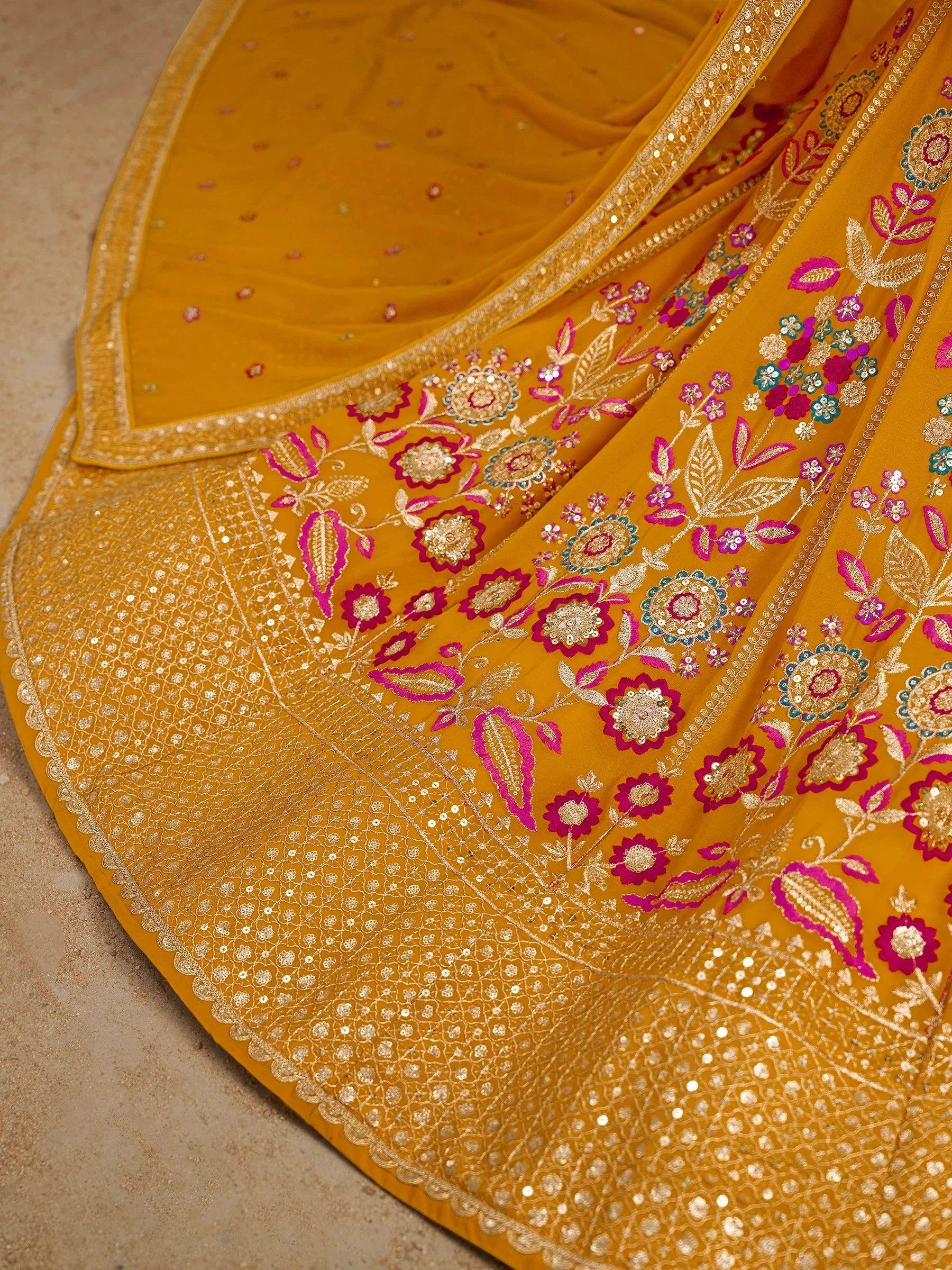 Mustard yellow lehenga with pink and gold floral embroidery and sequin detailing