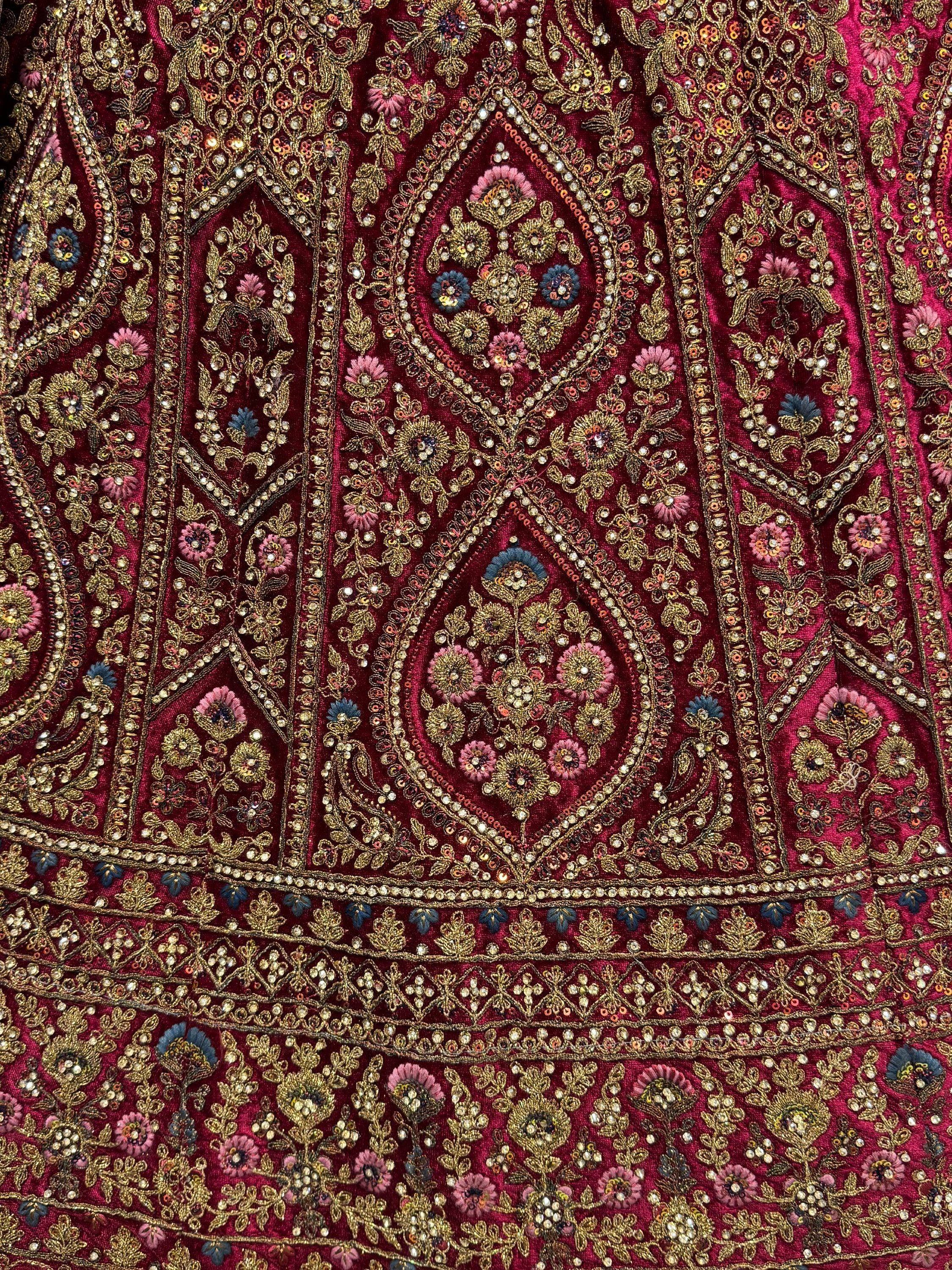 Richly embroidered maroon ethnic wear with gold floral patterns and beadwork