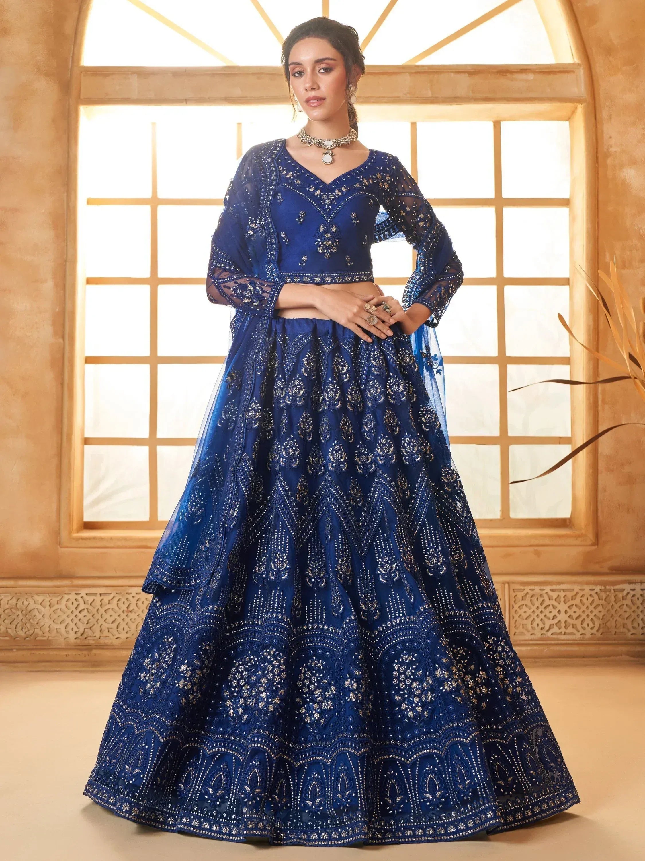 Royal blue embroidered lehenga choli with sheer sleeves, perfect for Indian weddings and festive occasions.