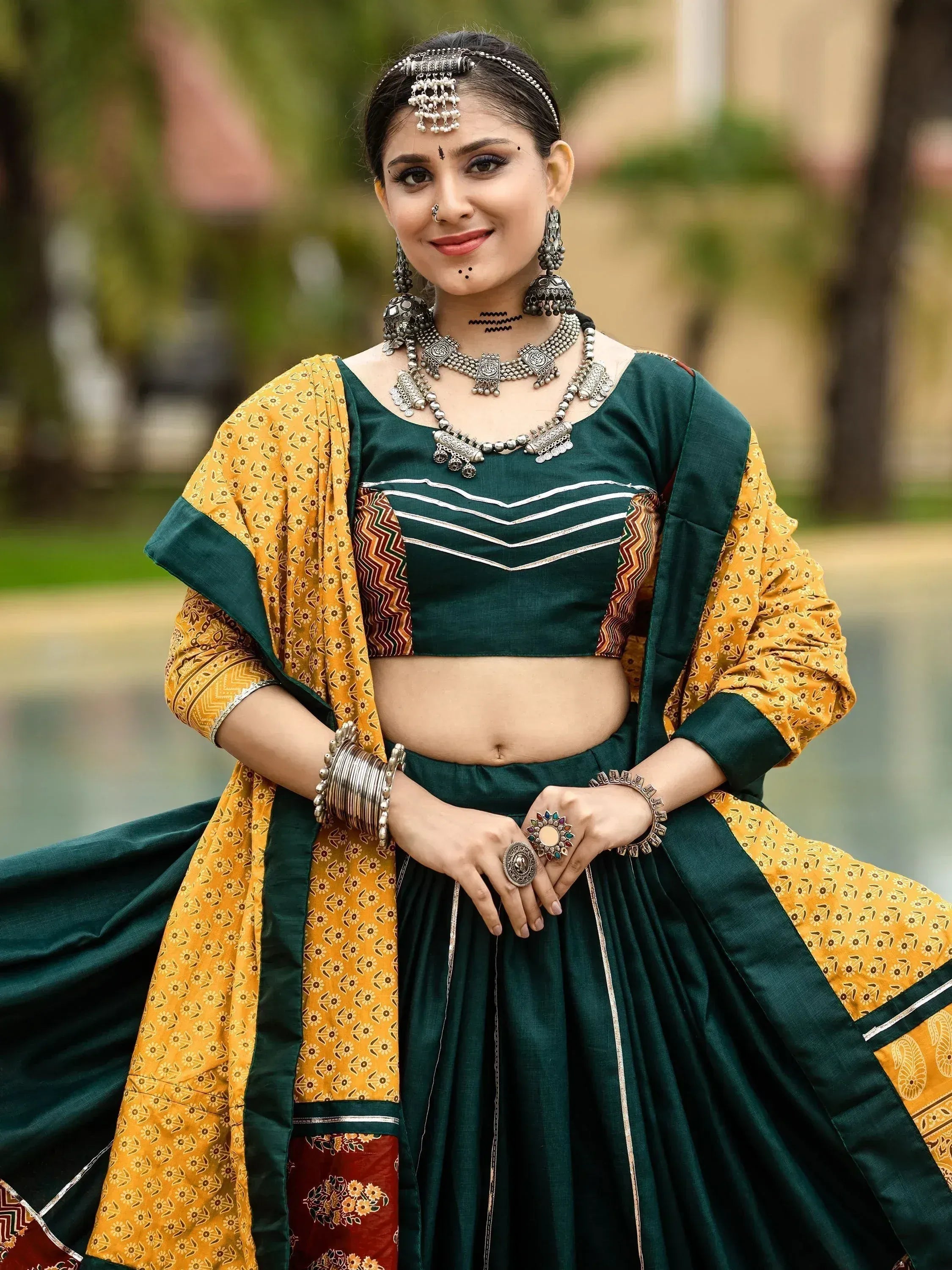 Woman in green and yellow ethnic lehenga choli with traditional jewelry, perfect for Indian festivals and weddings.