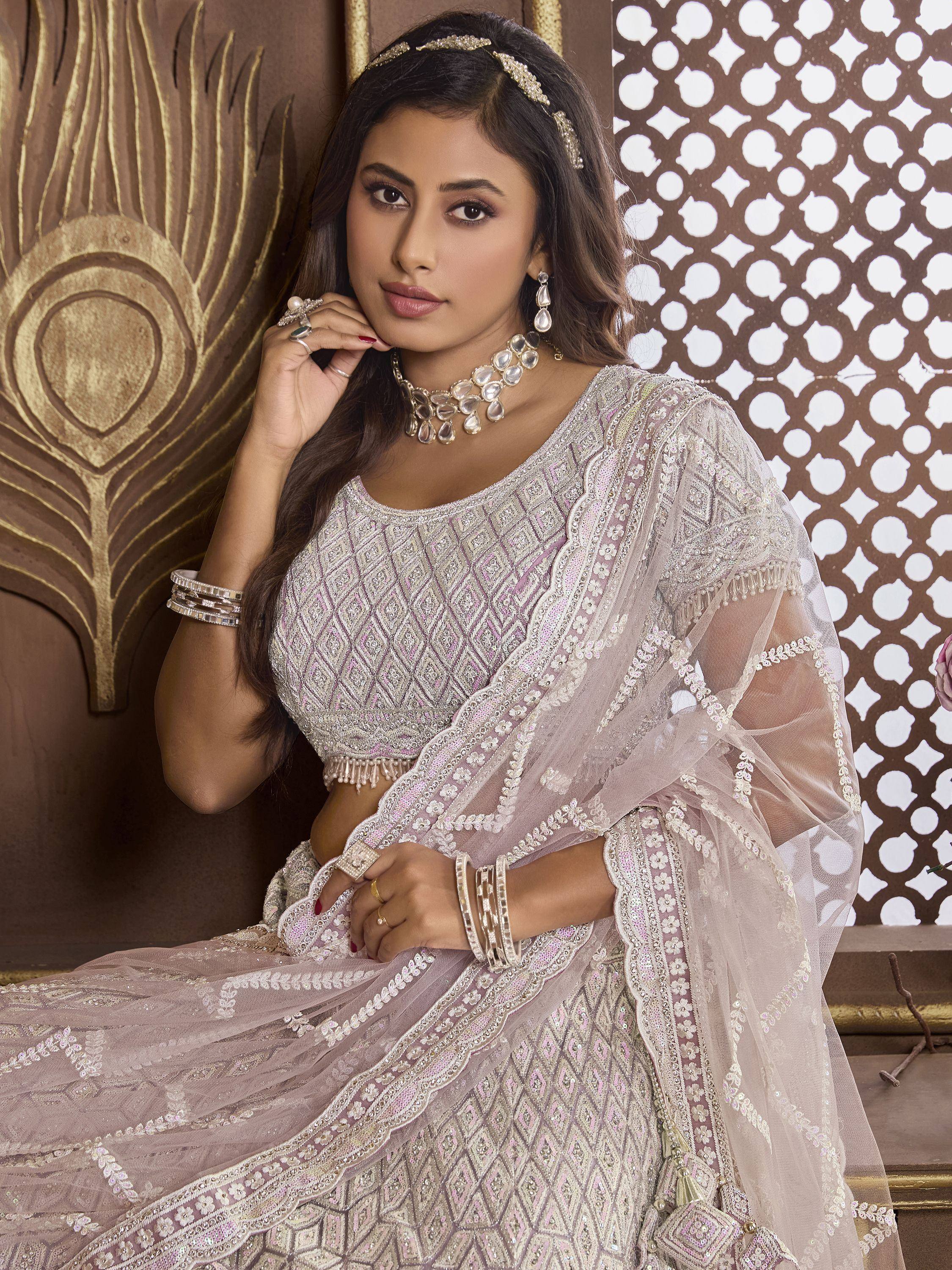 Elegant lavender lehenga choli with intricate embroidery and sheer dupatta, perfect for Indian weddings and festive occasions.
