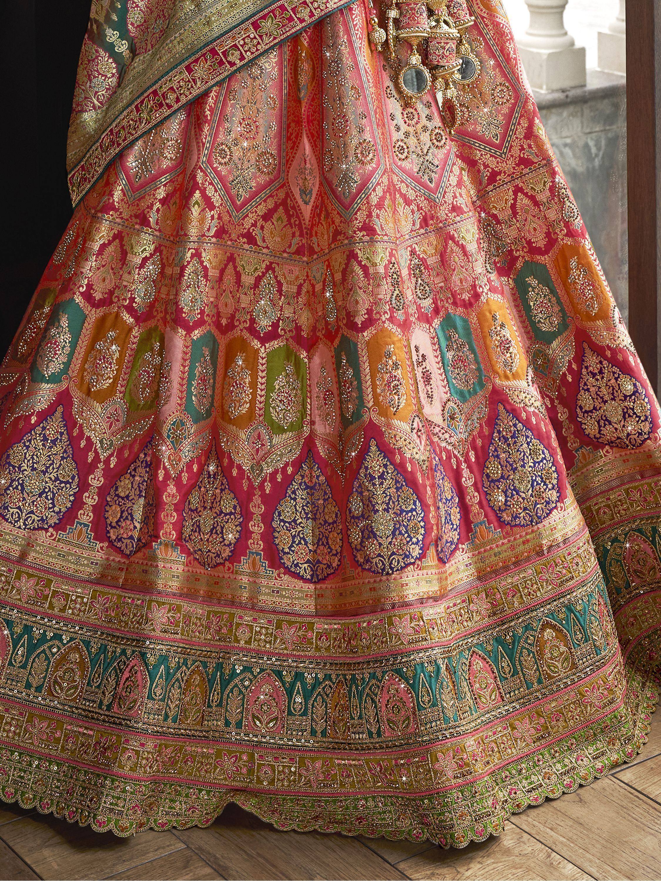 Luxury Indian lehenga choli with intricate gold embroidery, vibrant paisley patterns, and colorful embellishments for weddings.