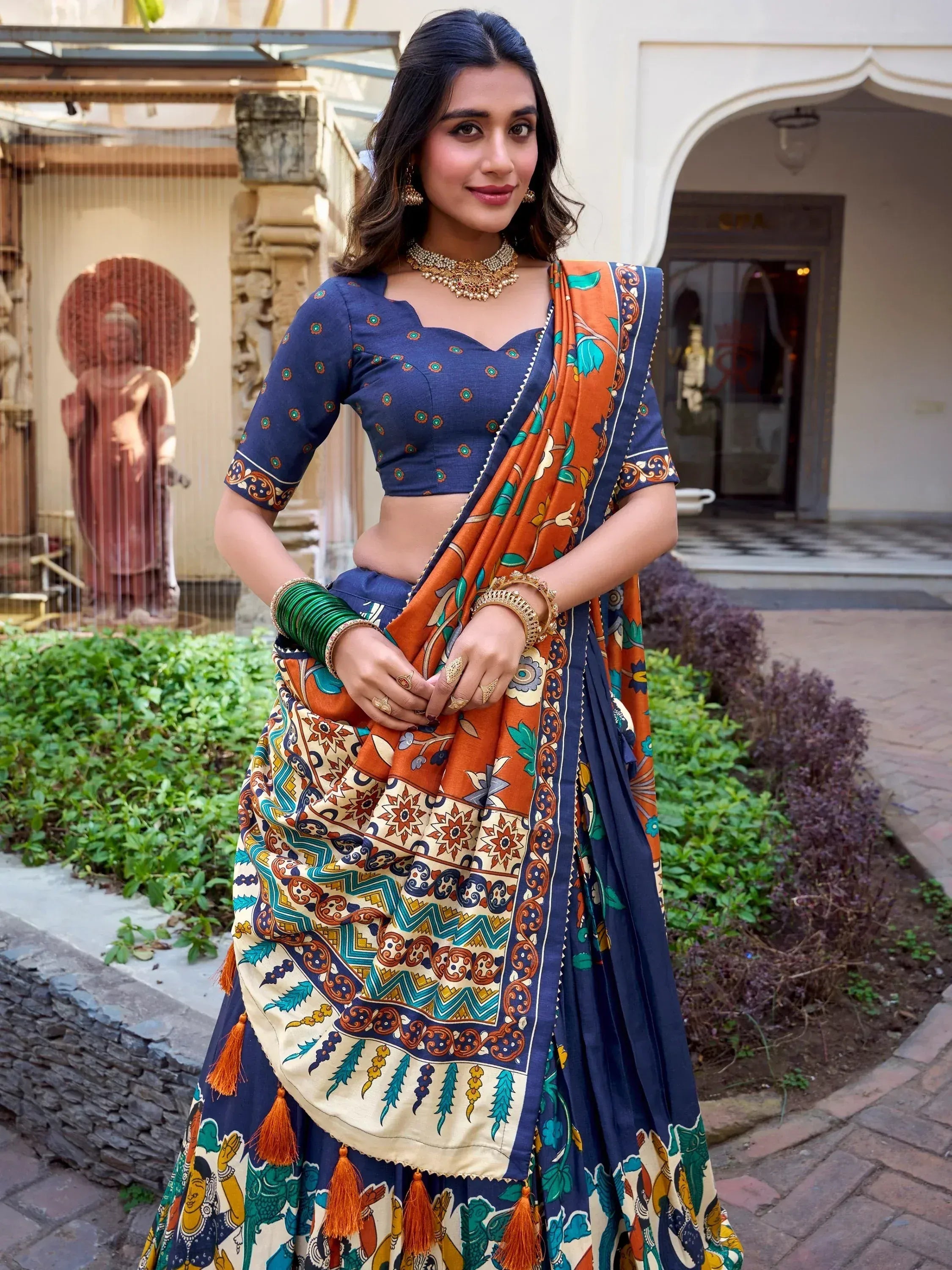 Woman in vibrant printed lehenga choli with orange and blue patterns, traditional Indian ethnic wear
