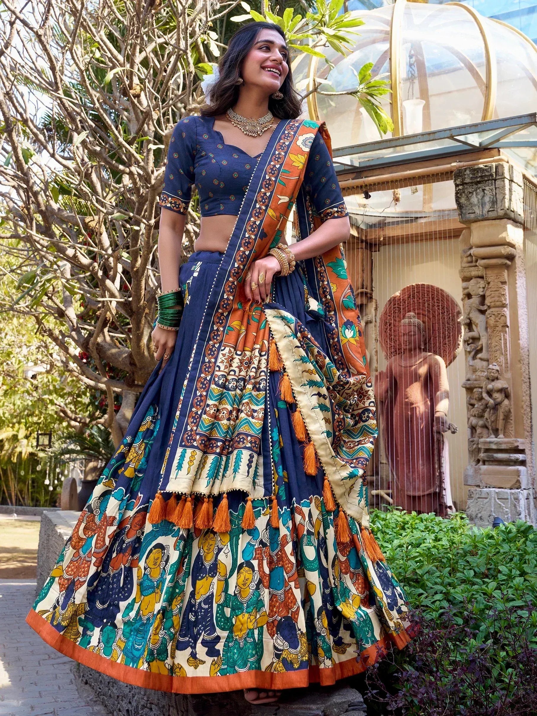 Woman in navy blue and orange printed lehenga choli with tassels, traditional Indian ethnic wear