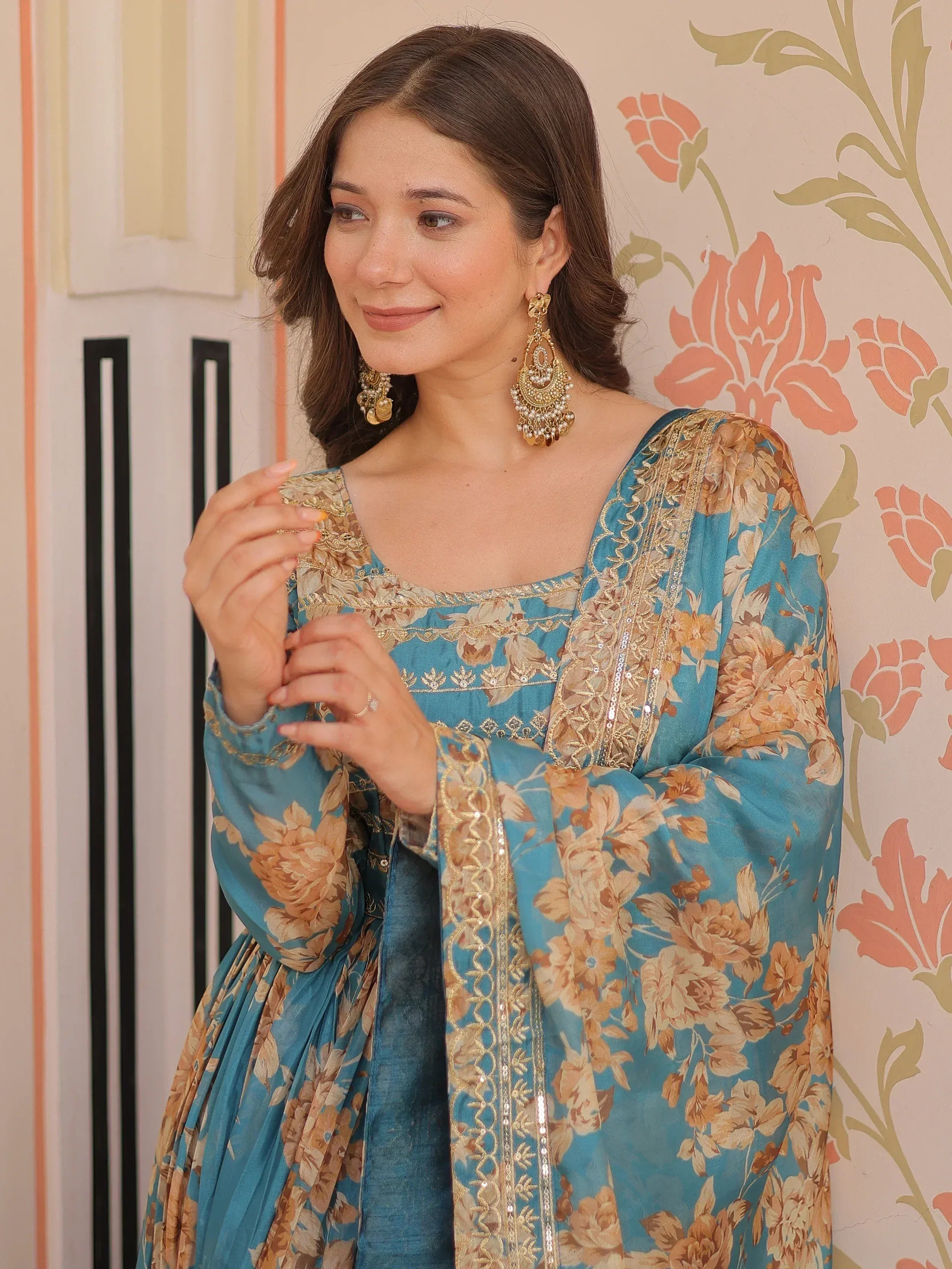 Woman in blue floral ethnic gown with gold embroidery and jhumka earrings