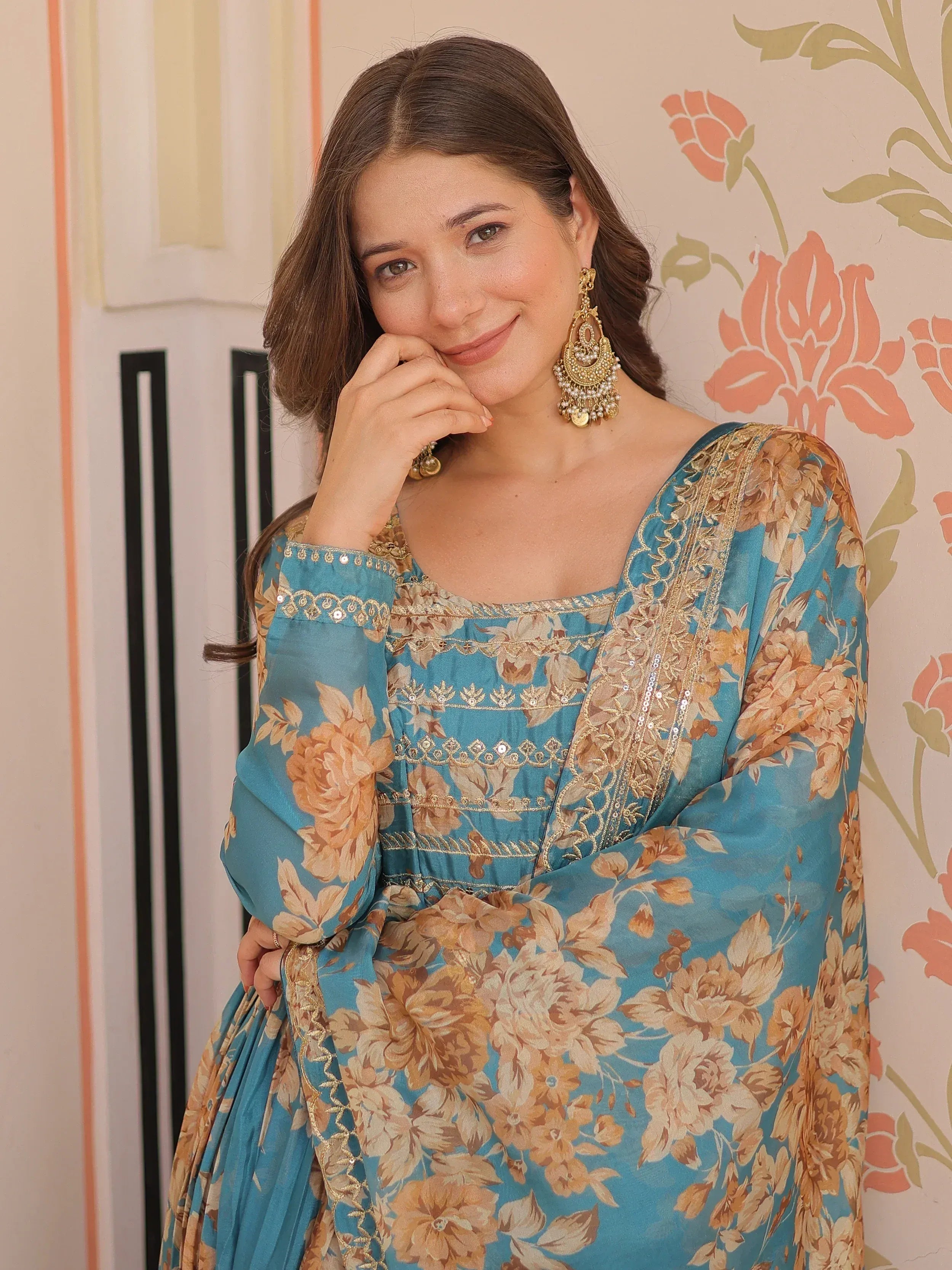 Blue floral ethnic gown with gold embroidery and statement earrings, perfect for Indian occasions