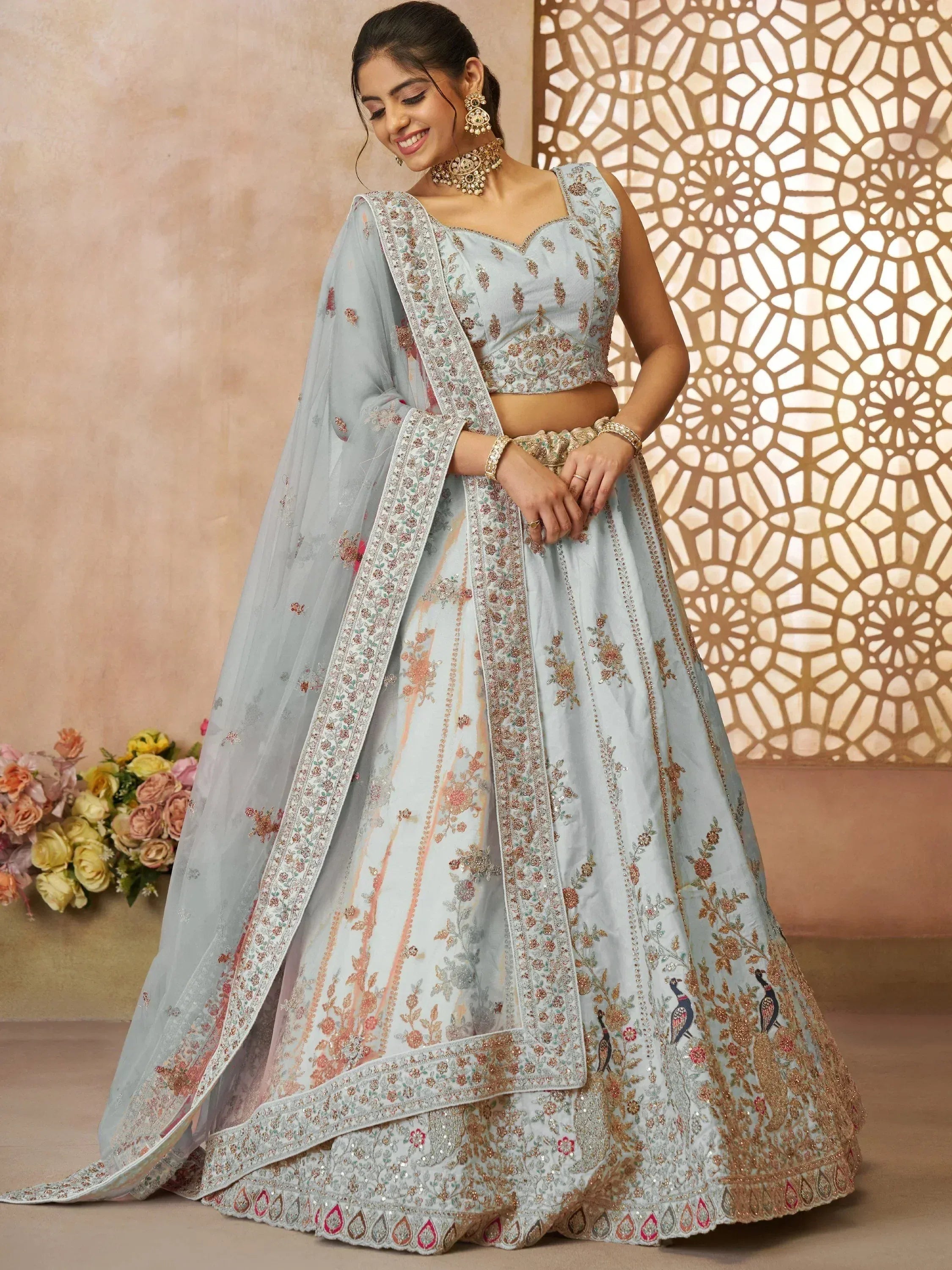 Light blue embroidered lehenga choli with floral and peacock motifs, perfect for Indian weddings and festive occasions.