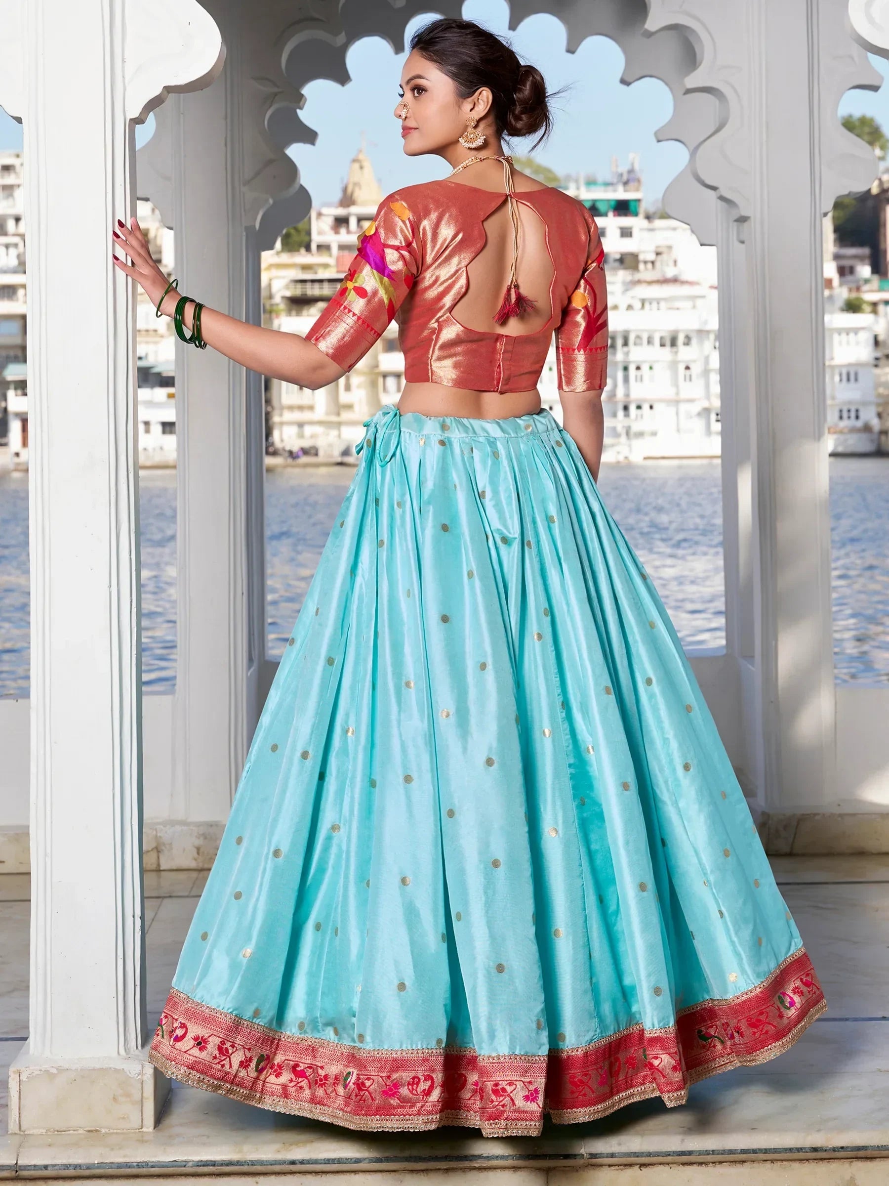Woman in turquoise lehenga with gold dots and coral embroidered blouse, traditional Indian ethnic wear