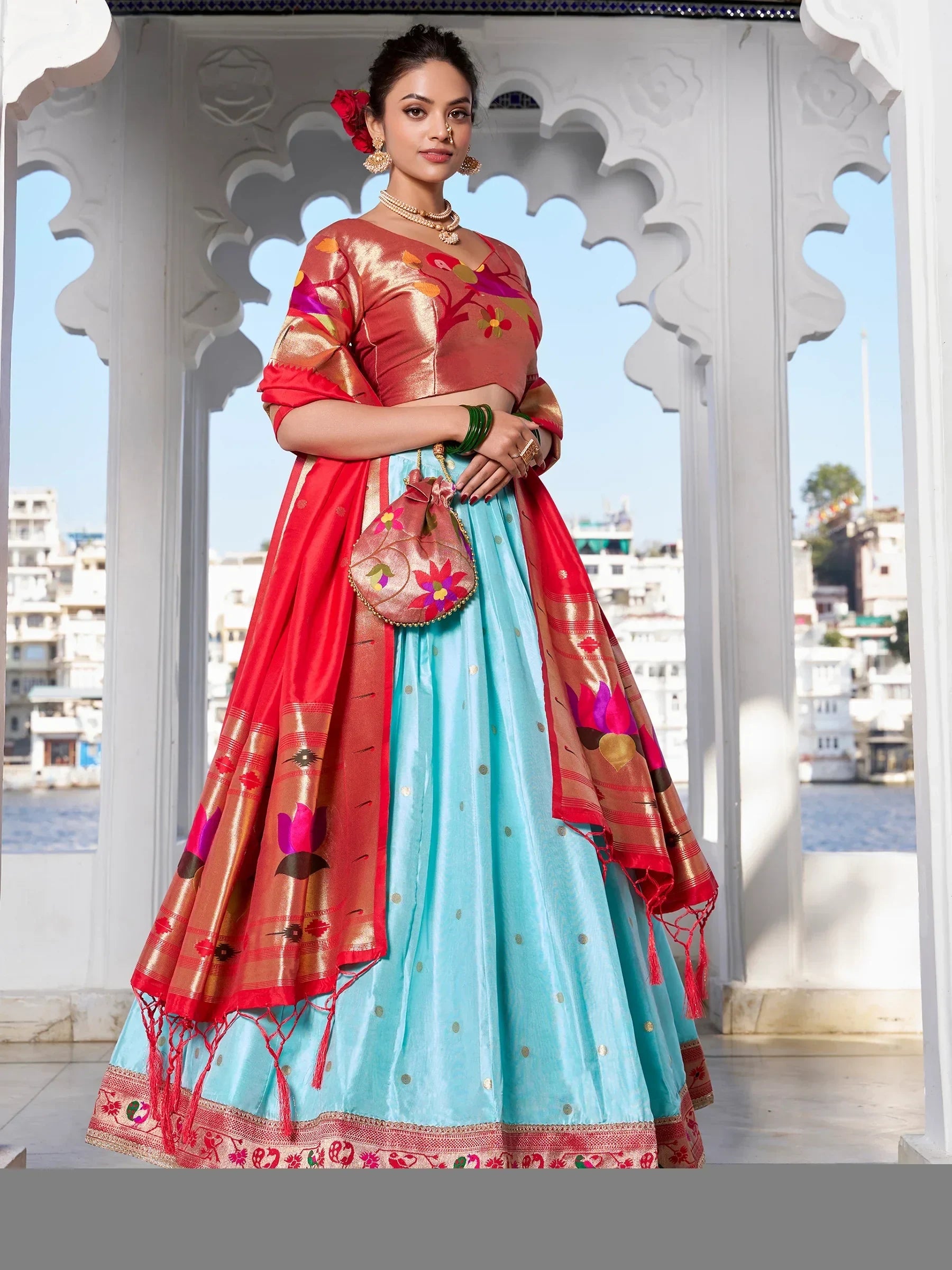 Woman in vibrant blue and red lehenga choli with floral embroidery, traditional Indian ethnic wear
