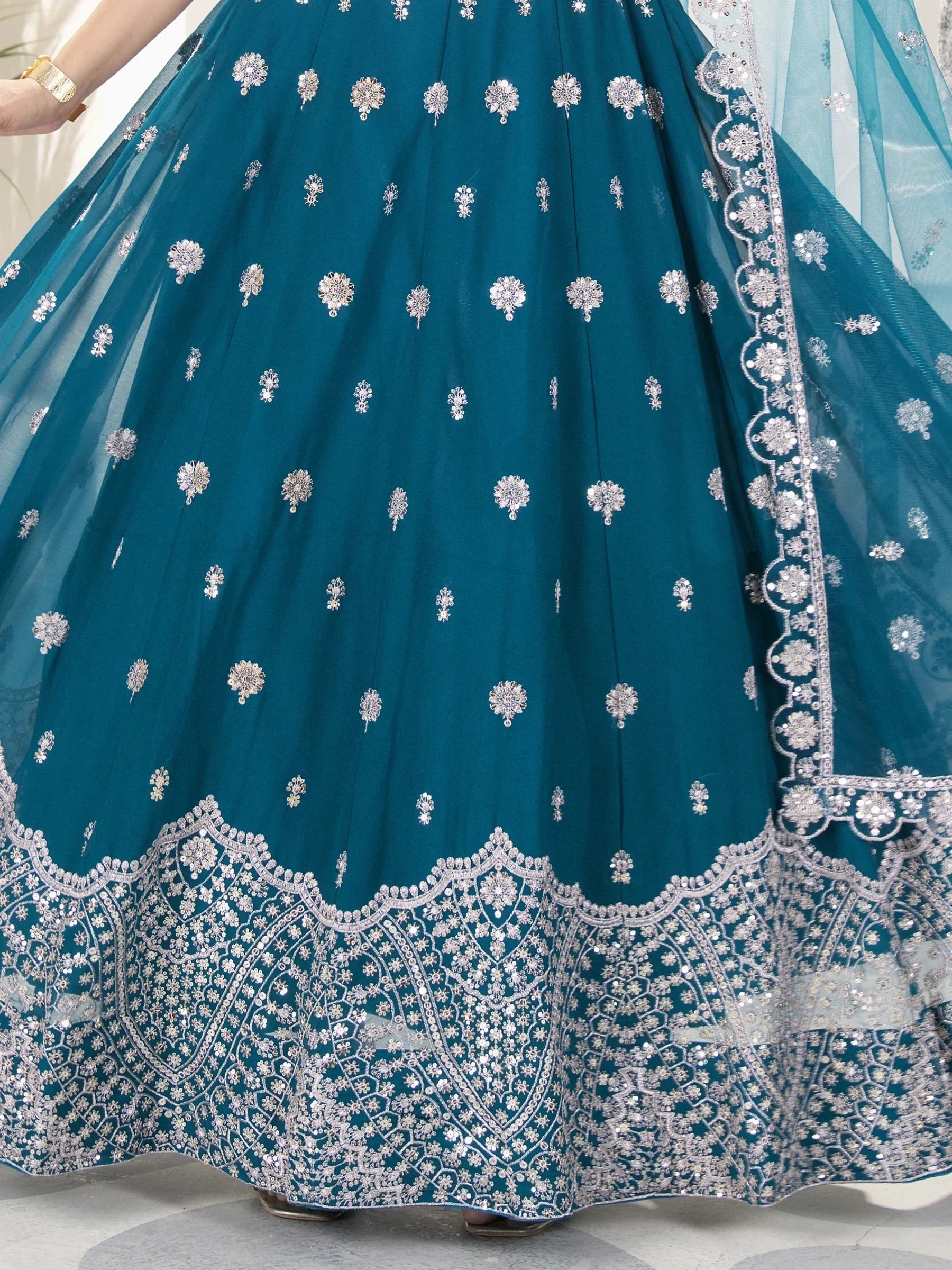 Teal designer lehenga with silver floral embroidery and scalloped border, perfect for Indian ethnic wear.
