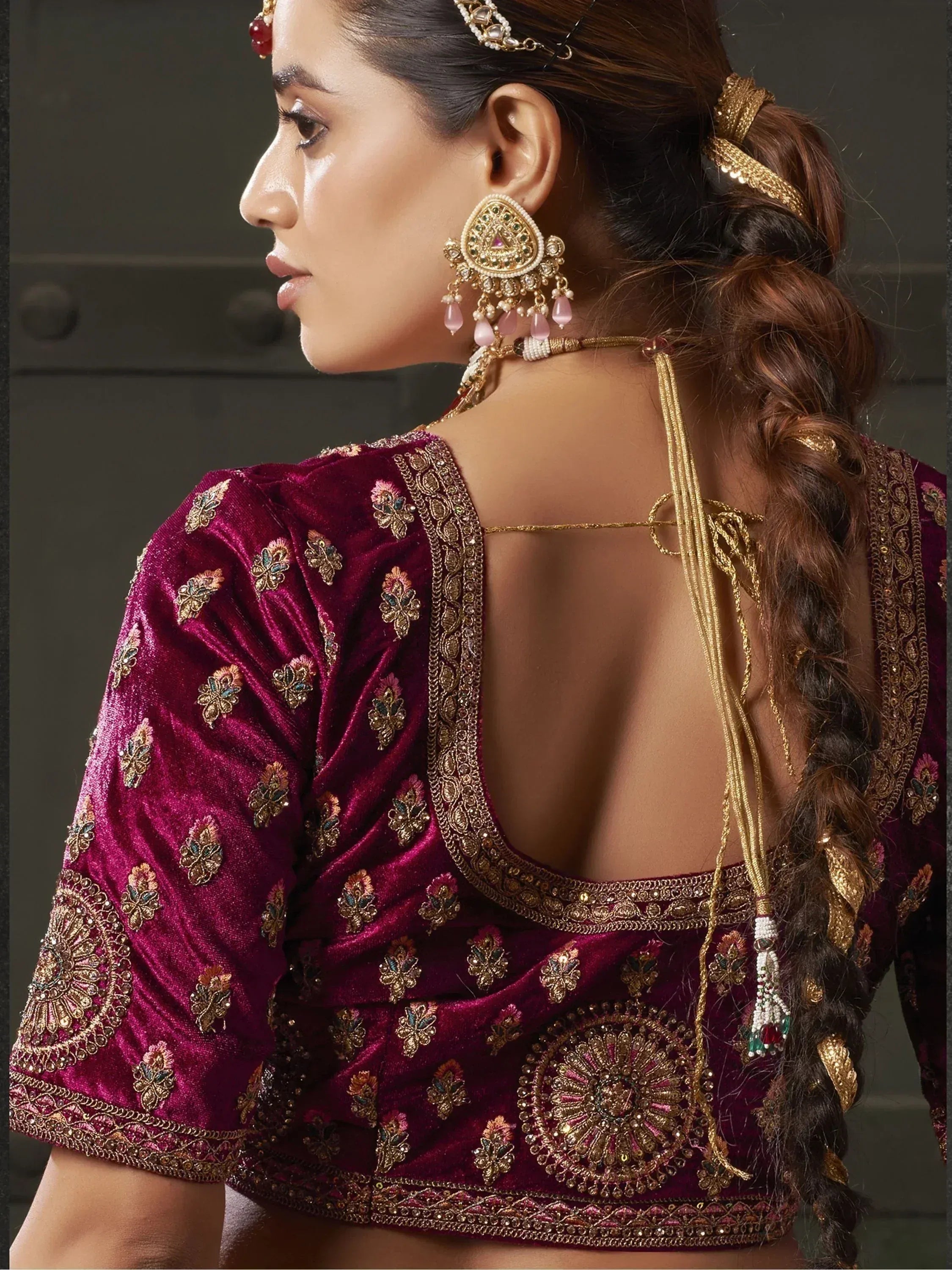 Maroon velvet designer blouse with gold embroidery, backless style, paired with traditional Indian jewelry