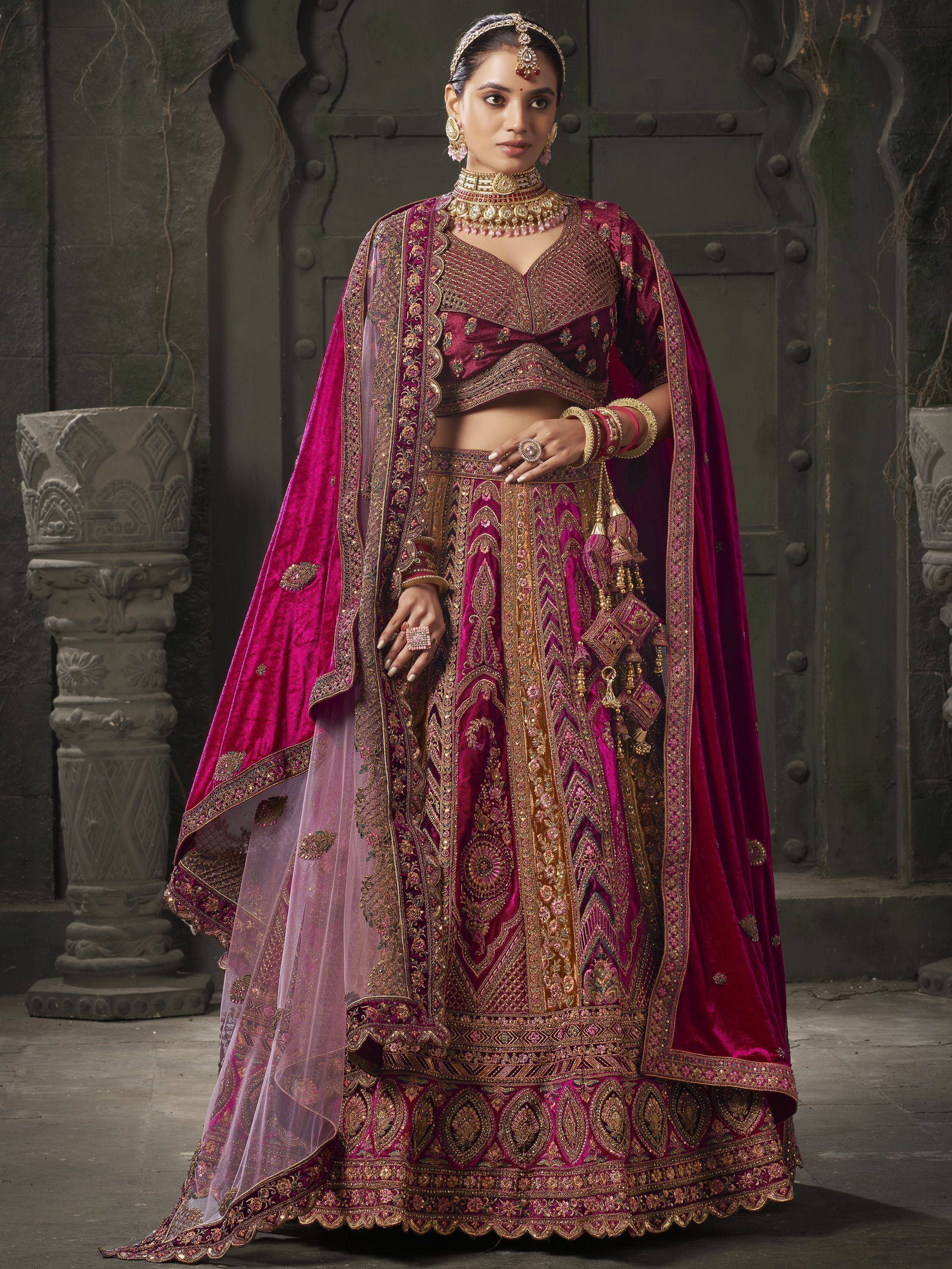 Luxury maroon velvet lehenga choli with heavy gold embroidery and dupatta, perfect for Indian weddings