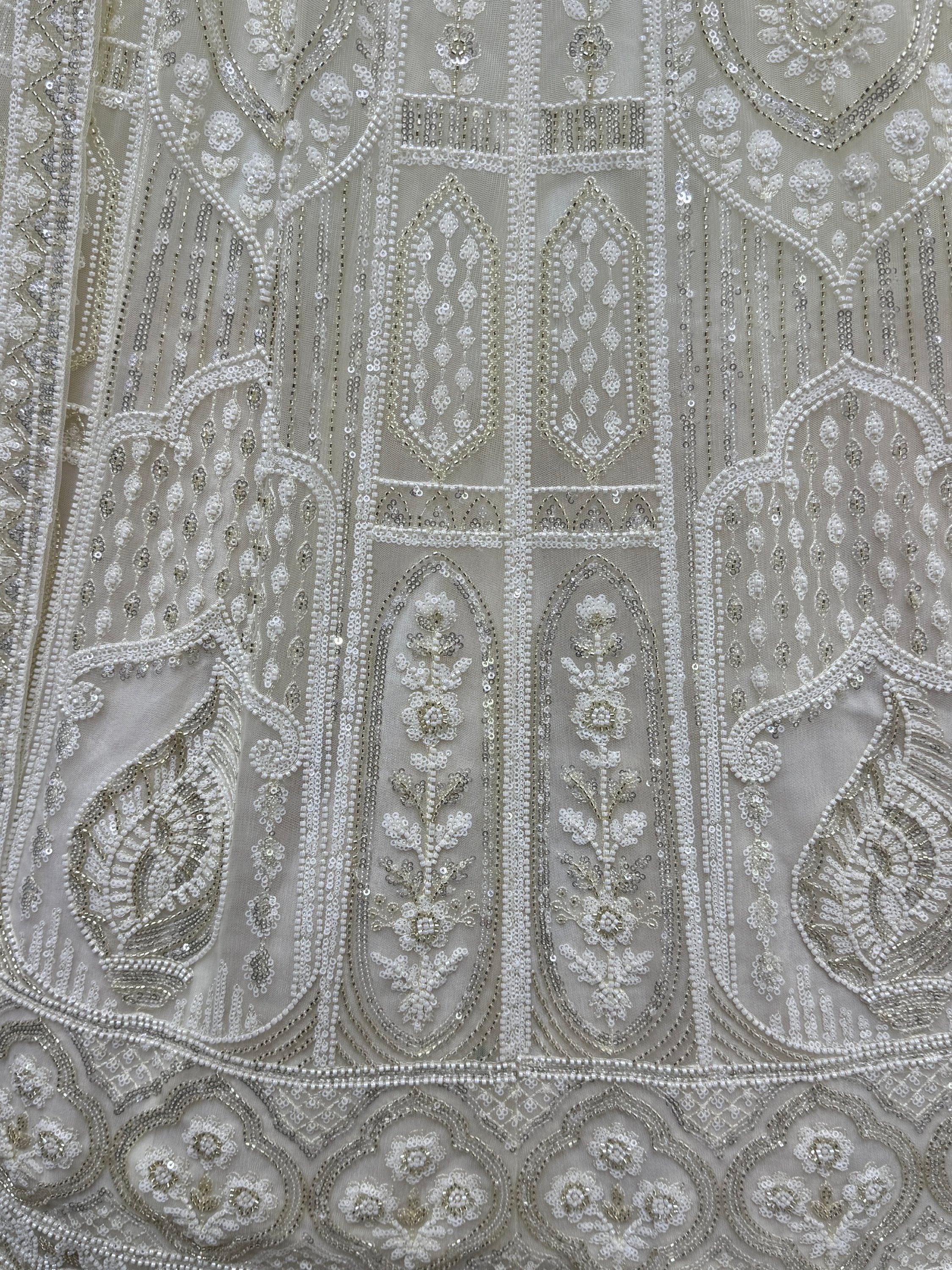 Exquisite white ethnic wear with intricate beadwork and sequin embroidery, perfect for Indian weddings and festive occasions.
