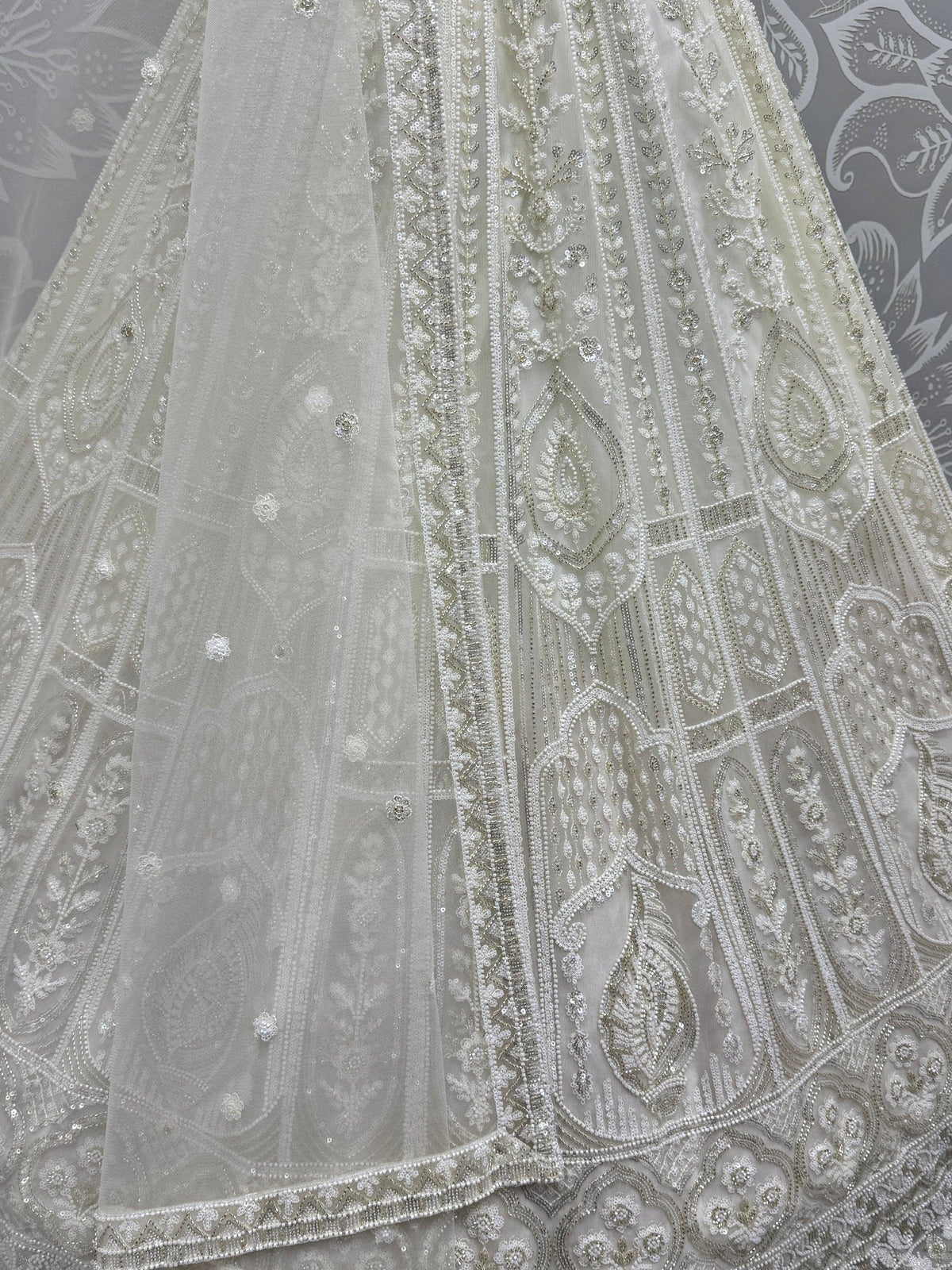 Elegant white ethnic gown with intricate beadwork and sequin embroidery, perfect for Indian weddings or festive occasions.