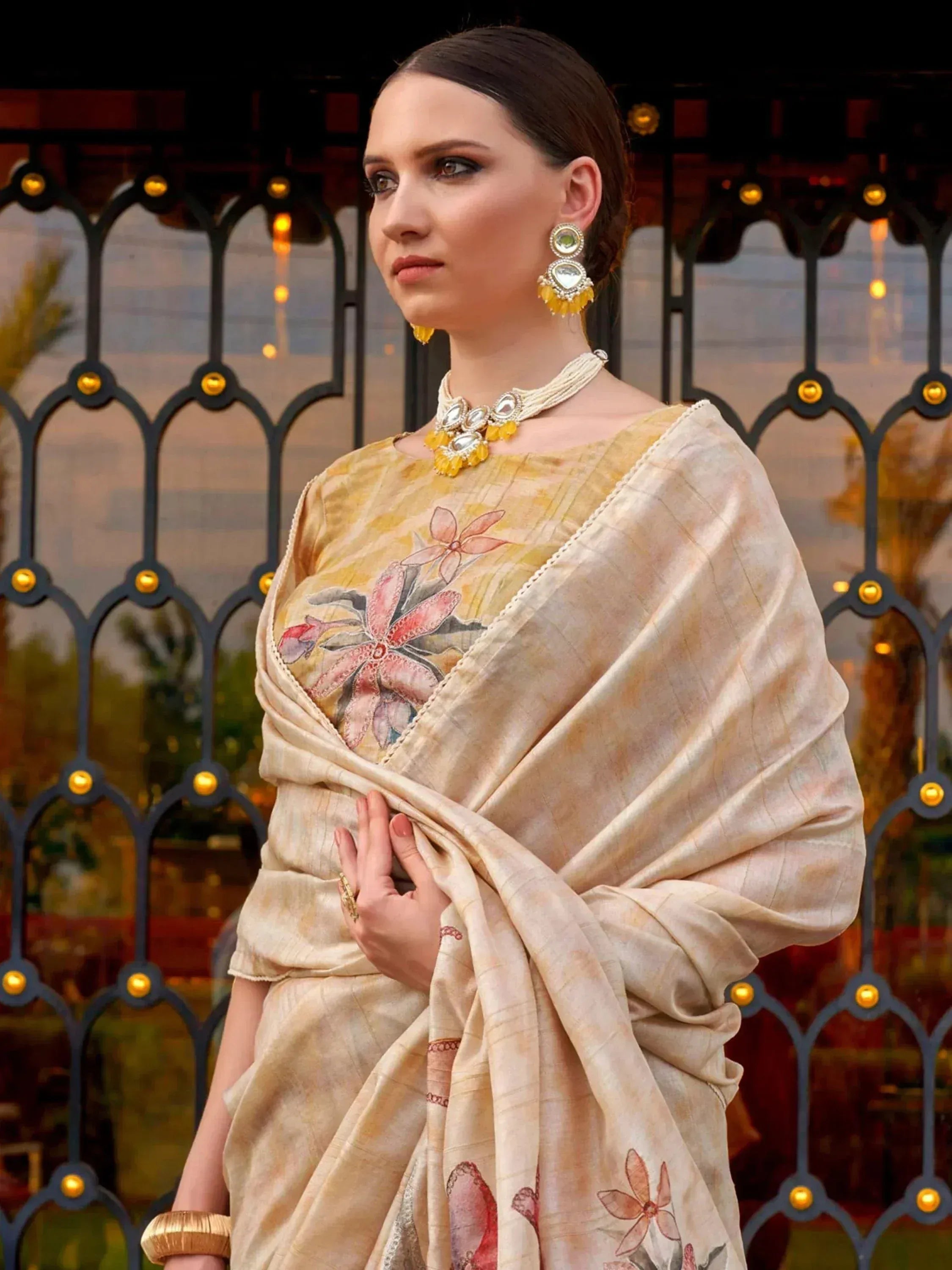 Elegant beige saree with floral embroidery, paired with traditional jewelry for Indian ethnic wear