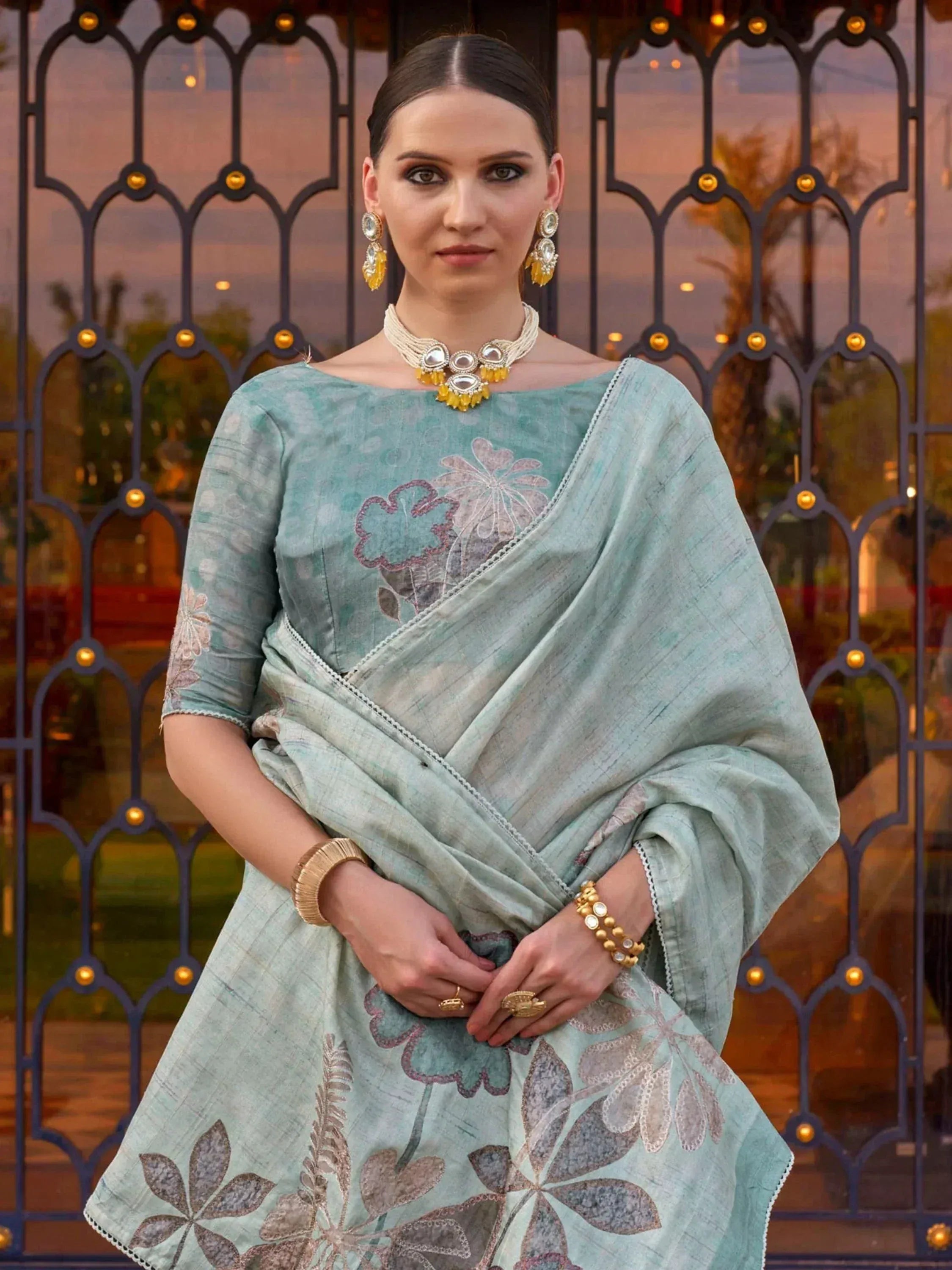 Elegant mint green floral printed saree with embroidered blouse, styled with traditional jewelry for Indian ethnic wear.