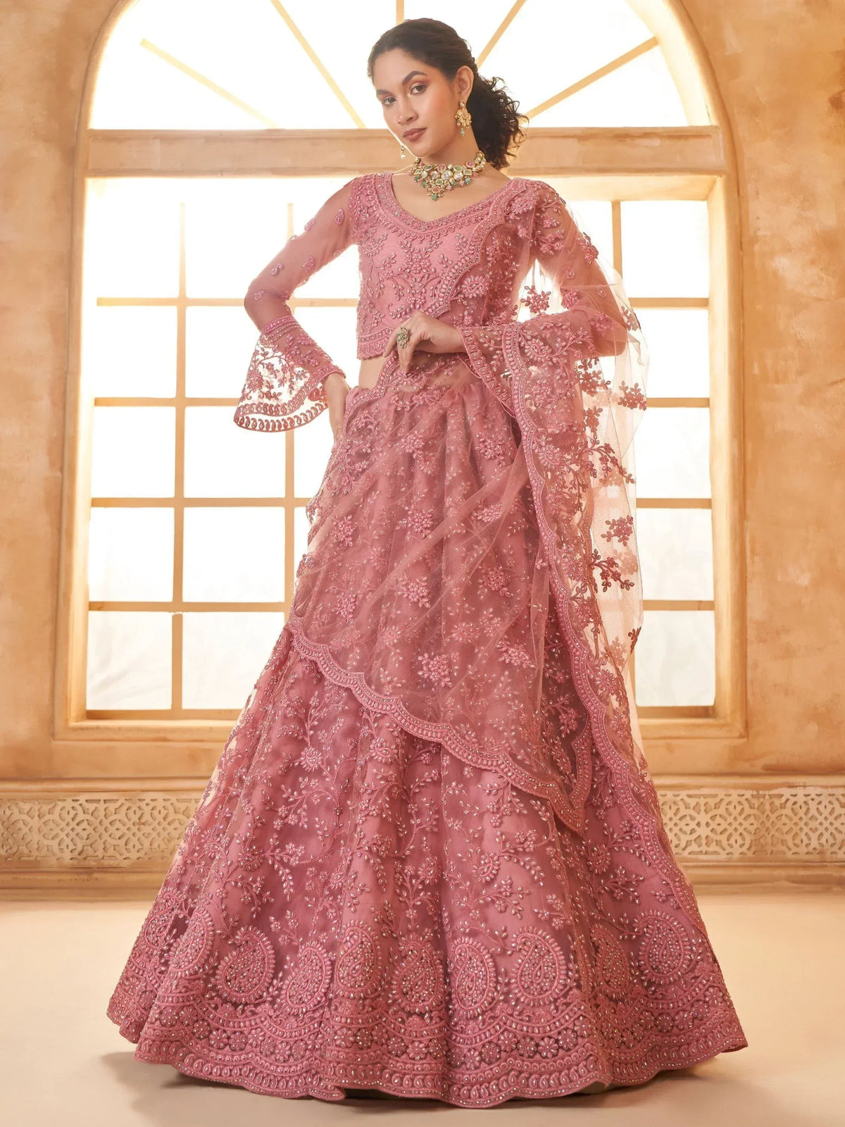 Pink embroidered lehenga choli with bell sleeves, perfect for Indian weddings and festive occasions