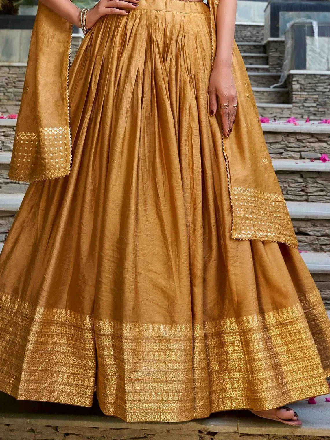 Golden designer lehenga choli with intricate embroidery and pleated skirt, perfect for Indian ethnic wear