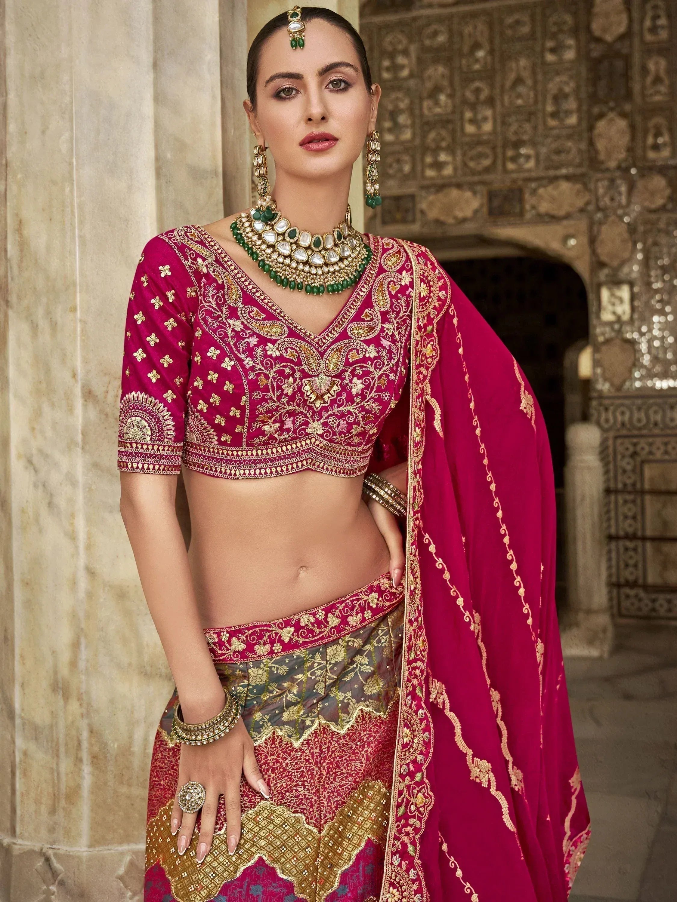 Elegant magenta lehenga choli with gold embroidery, perfect for Indian weddings and festive occasions.