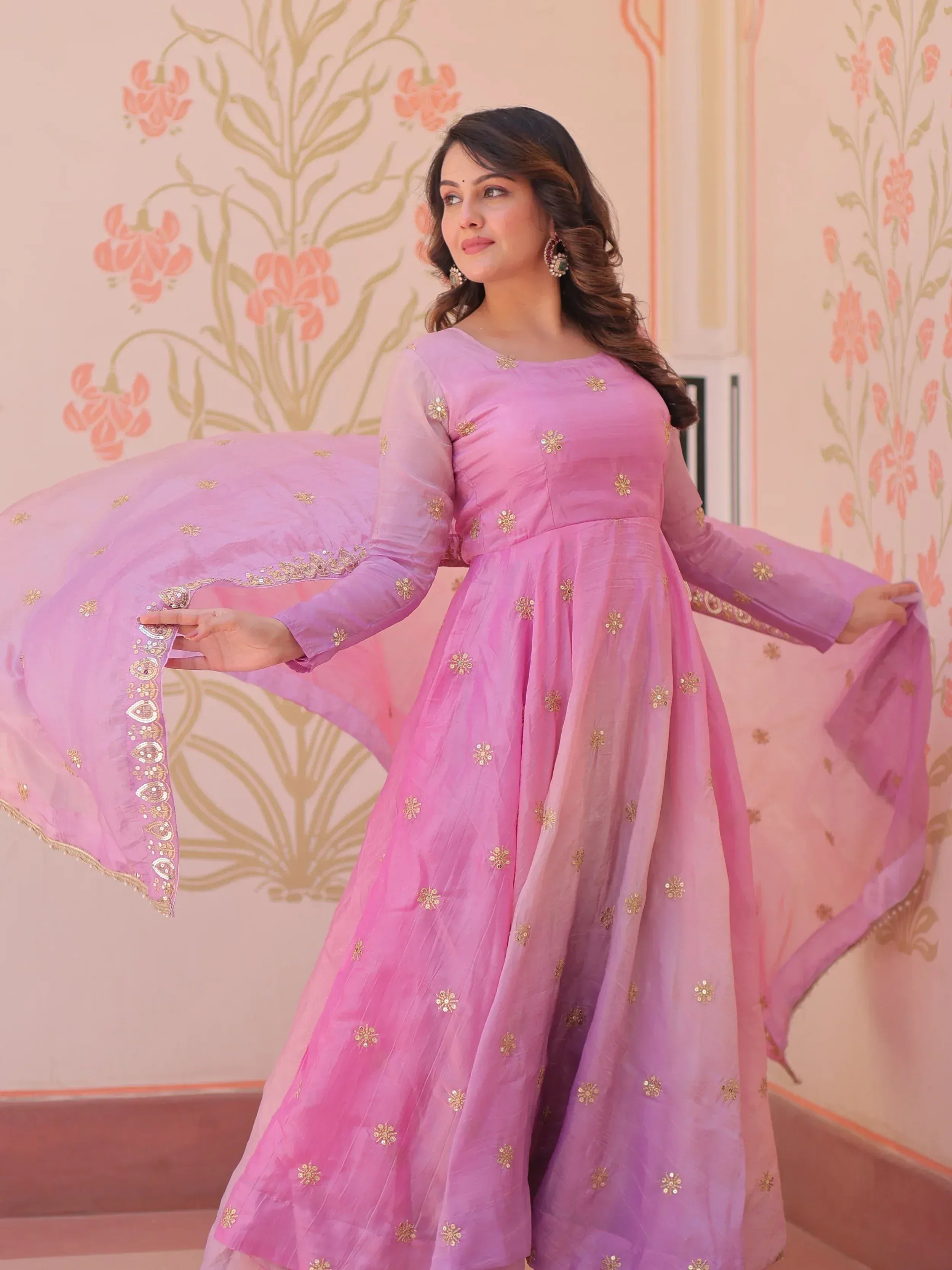 Pink embroidered ethnic gown with gold floral motifs and sheer sleeves, perfect for Indian occasions