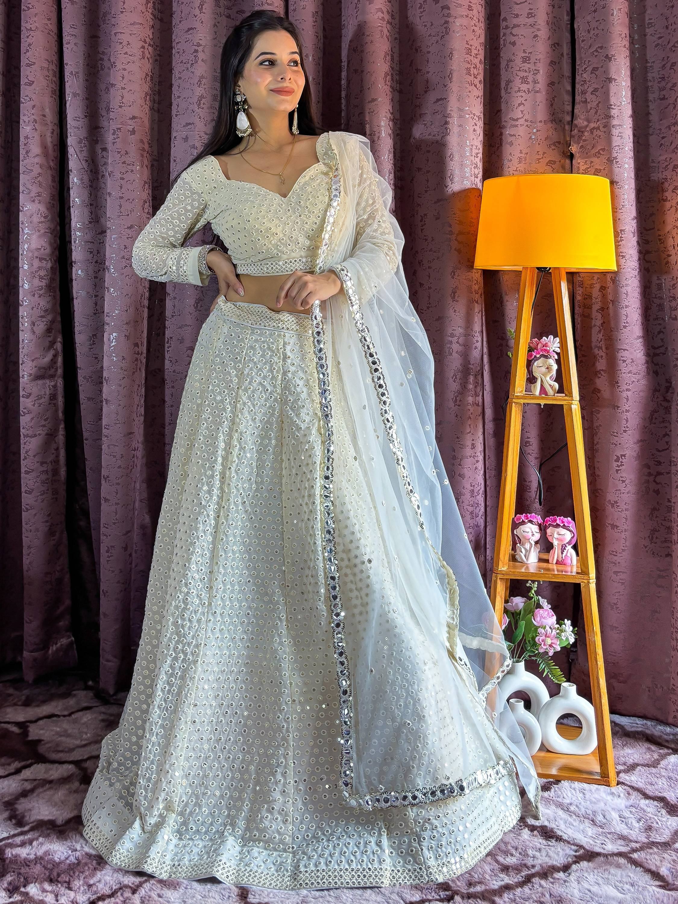 Elegant ivory lehenga choli with mirror work and sheer dupatta, perfect for Indian ethnic occasions