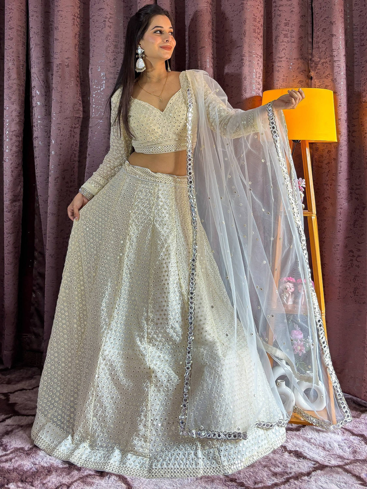 Elegant ivory lehenga choli with mirror work and sheer dupatta, perfect for Indian ethnic occasions.