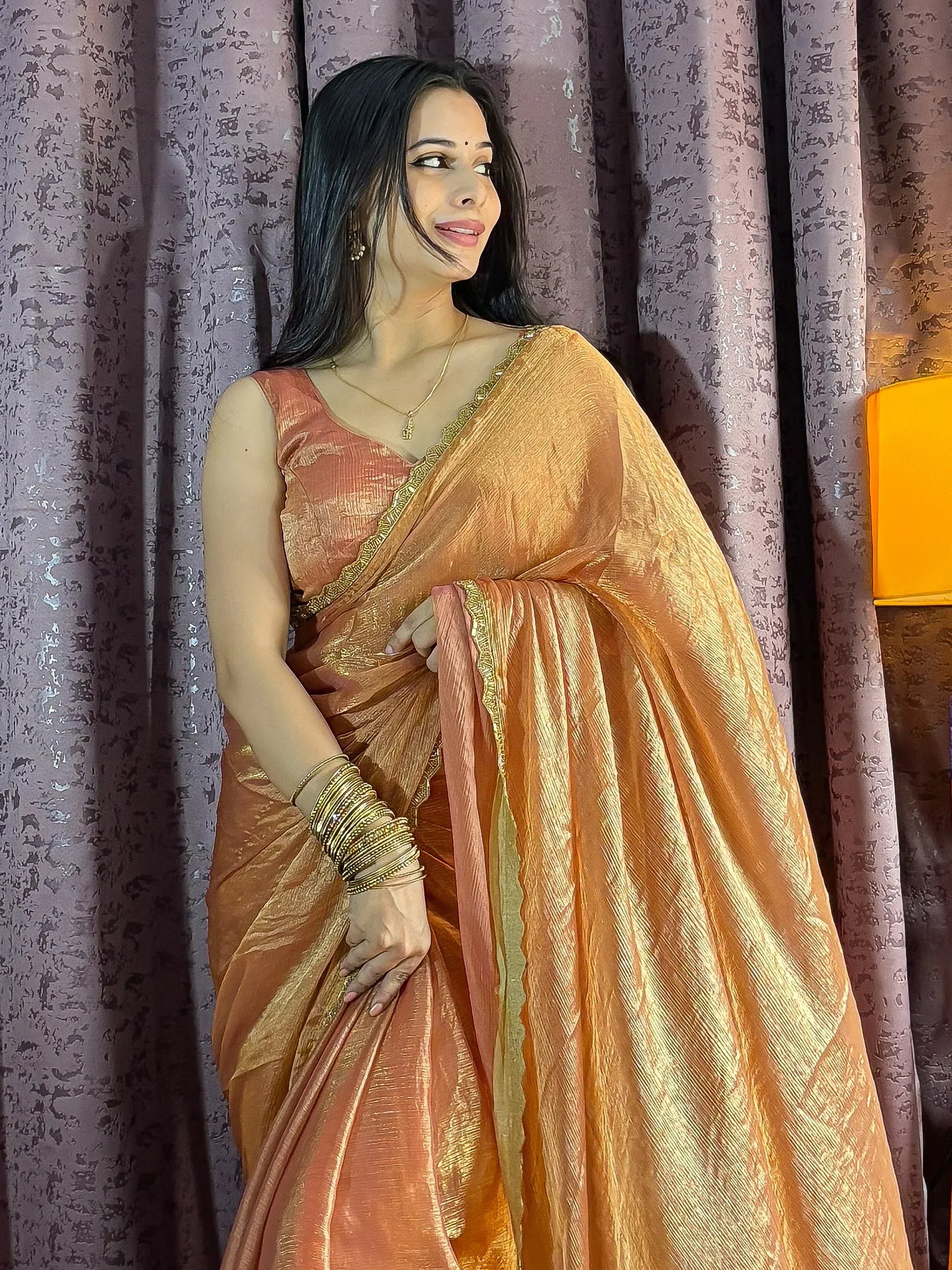 Woman in elegant peach saree with gold border, traditional Indian ethnic wear for festive occasions