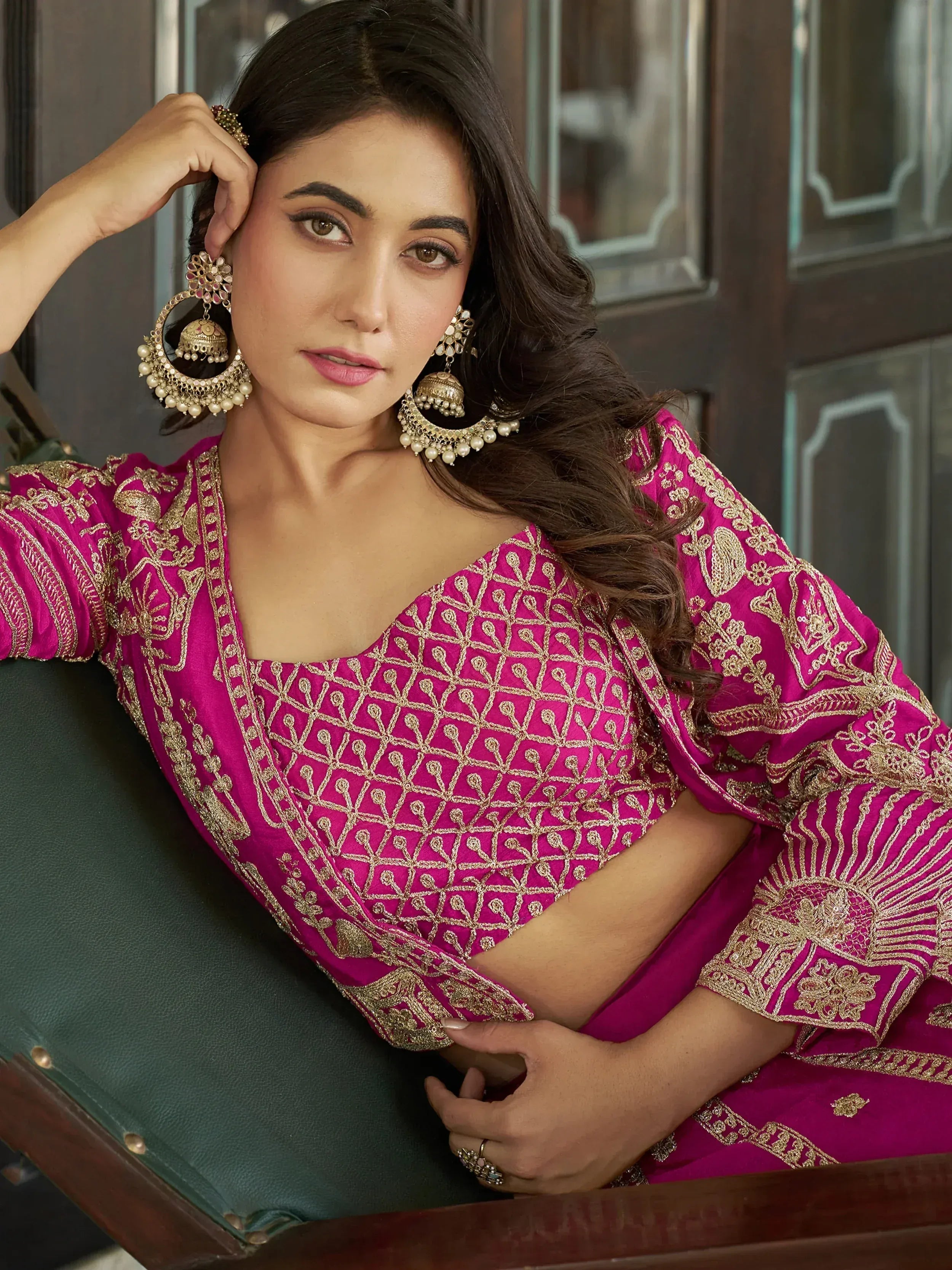 Woman in magenta ethnic wear with gold embroidery and jhumka earrings, styled for Indian occasions