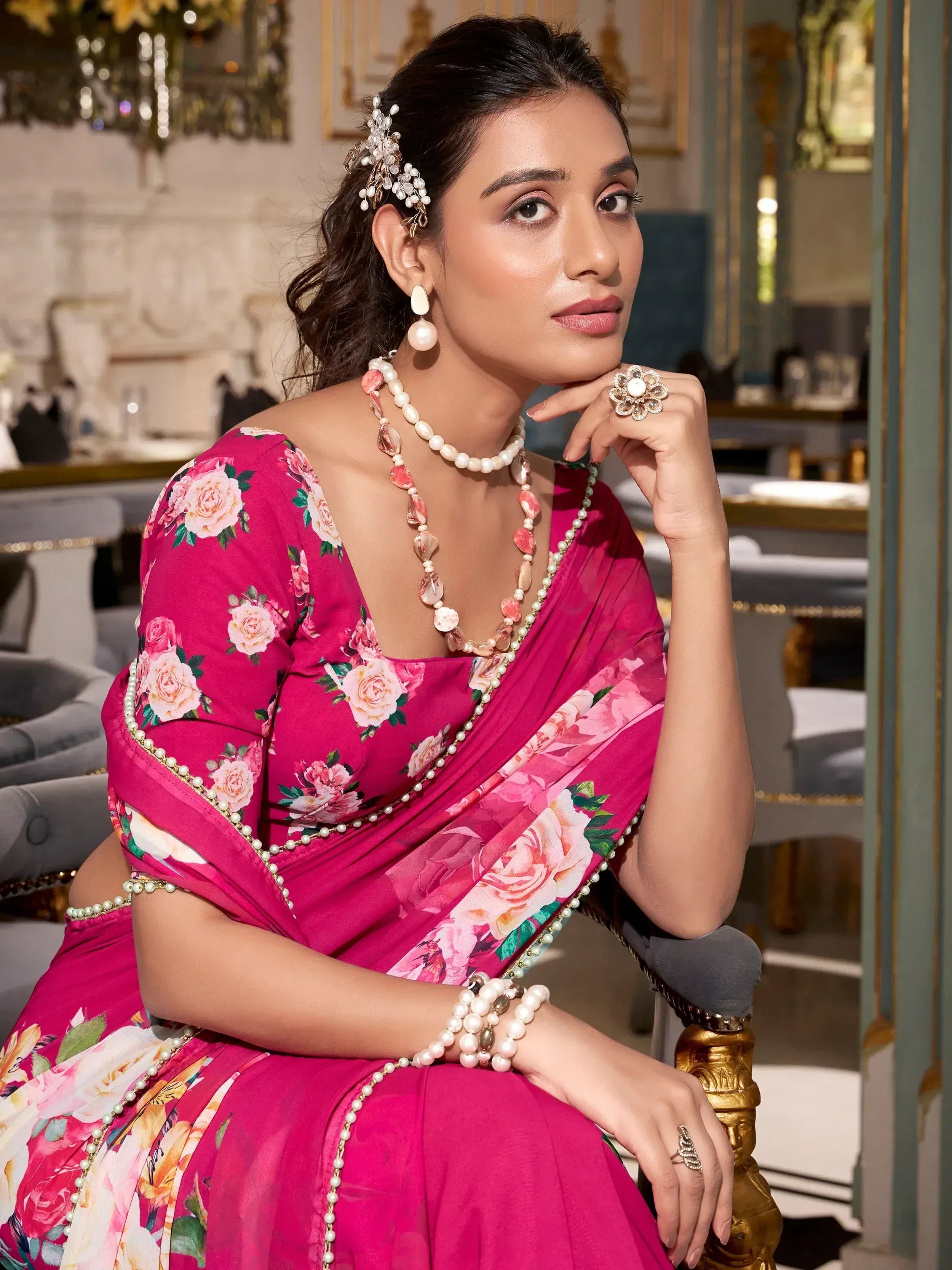 Woman in pink floral saree with pearl jewelry, elegant ethnic wear for special occasions