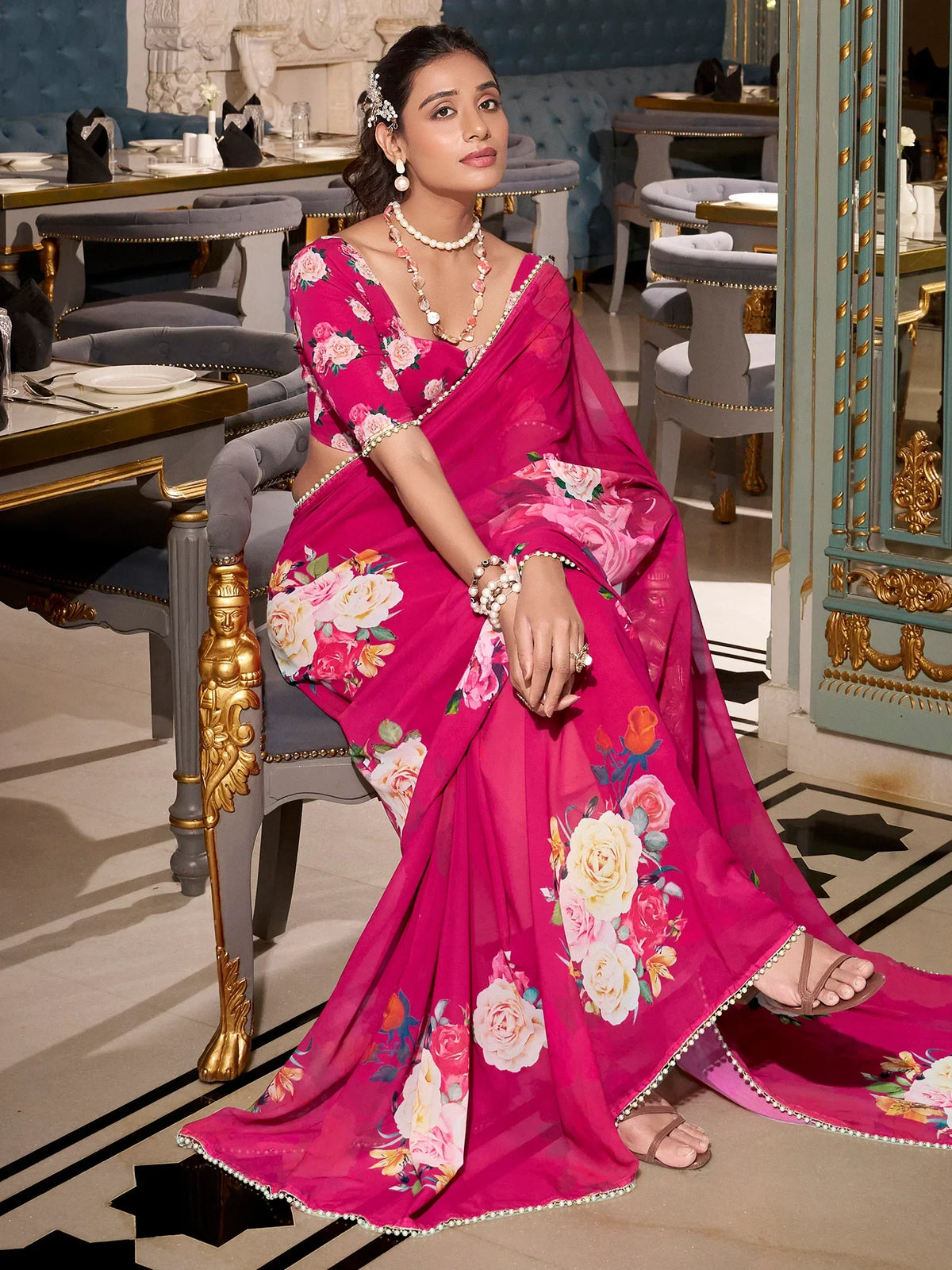 Woman in vibrant pink floral saree with pearl trim, styled for Indian ethnic wear occasions