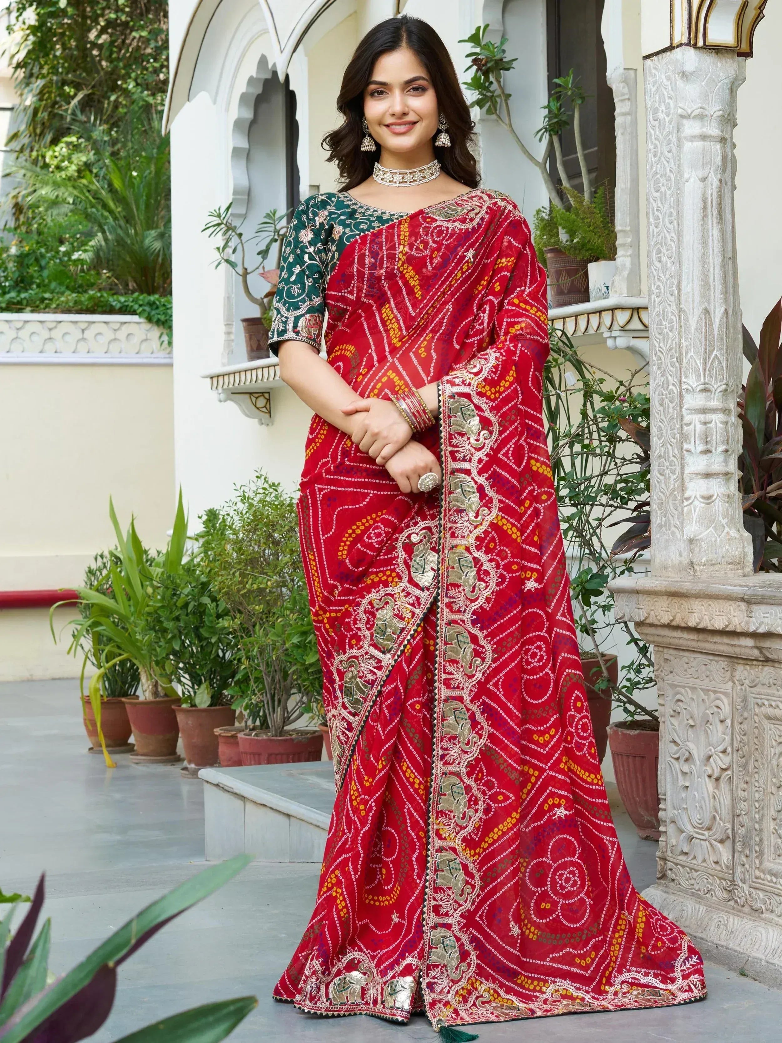 Red embroidered saree with elephant motifs, paired with green blouse, perfect for Indian ethnic occasions