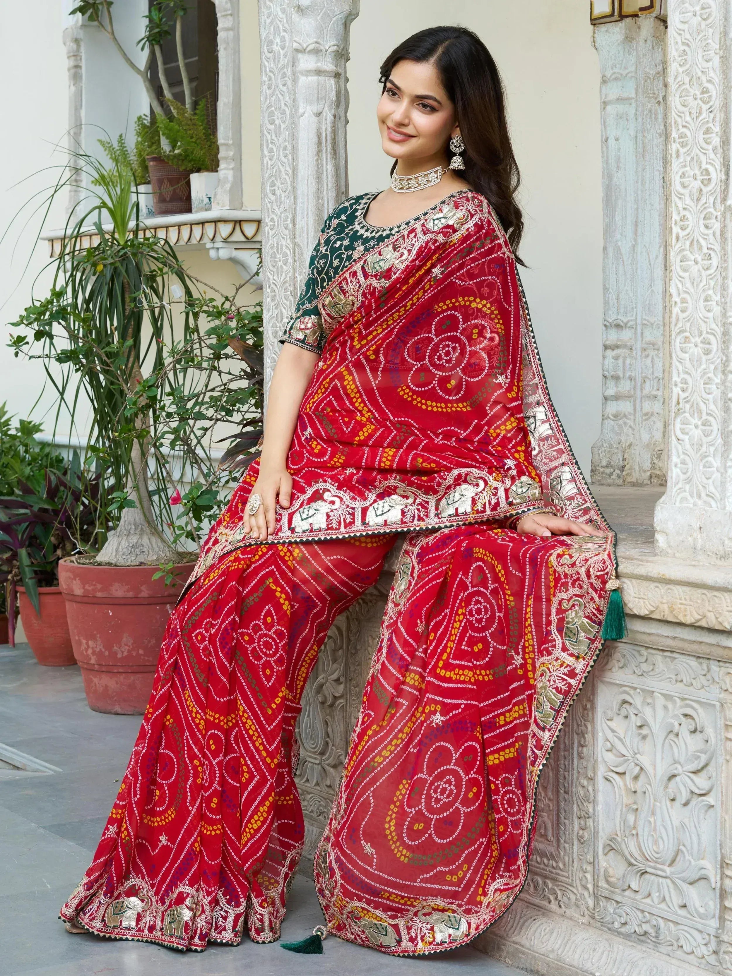 Red embroidered saree with elephant motifs, paired with green blouse, perfect for Indian ethnic occasions.